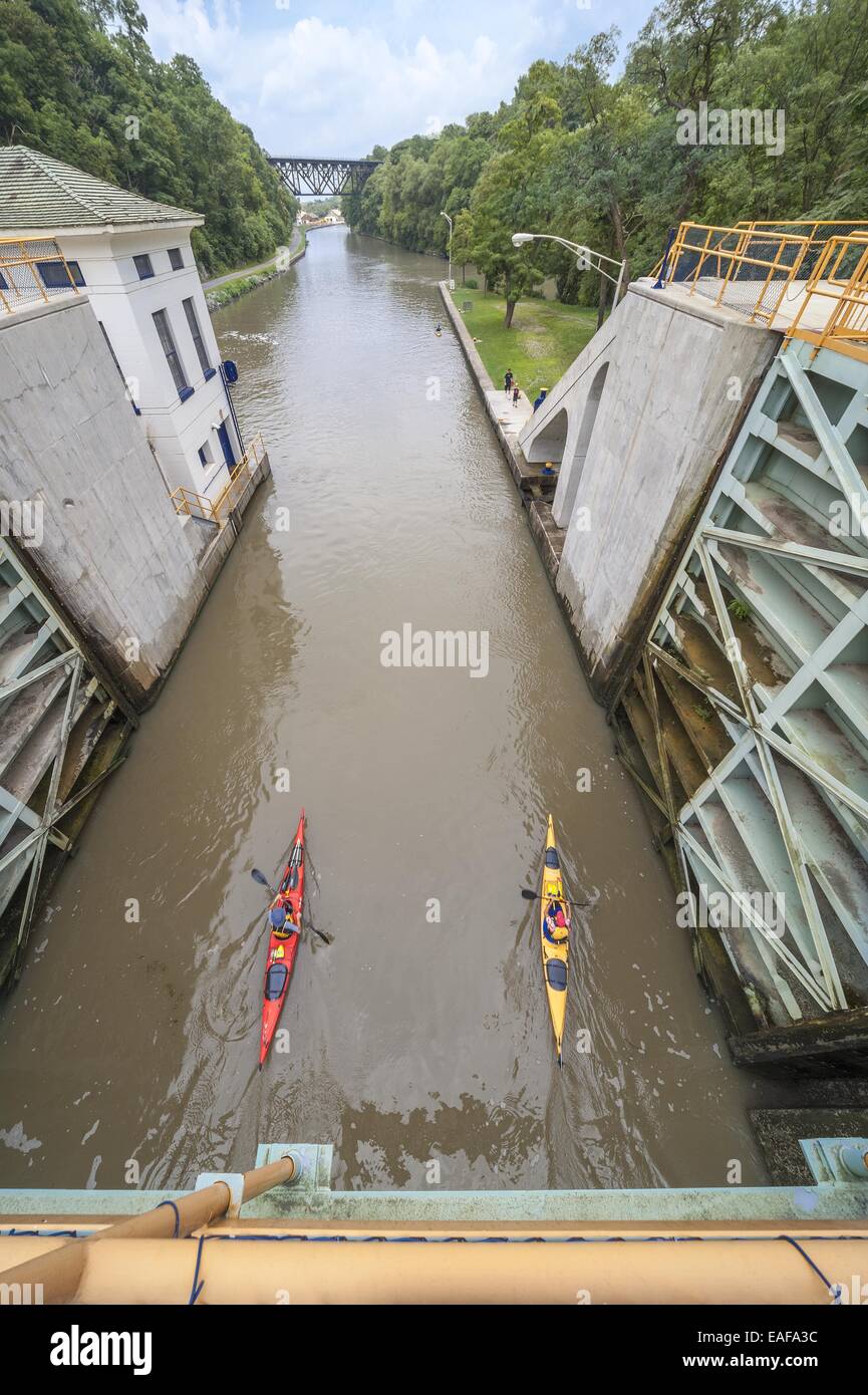 Kajak Eriekanal Lockport. Drei Kajaks paddeln aus Schloss 34 in Richtung der Upside Down Truss-Eisenbahnbrücke Stockfoto