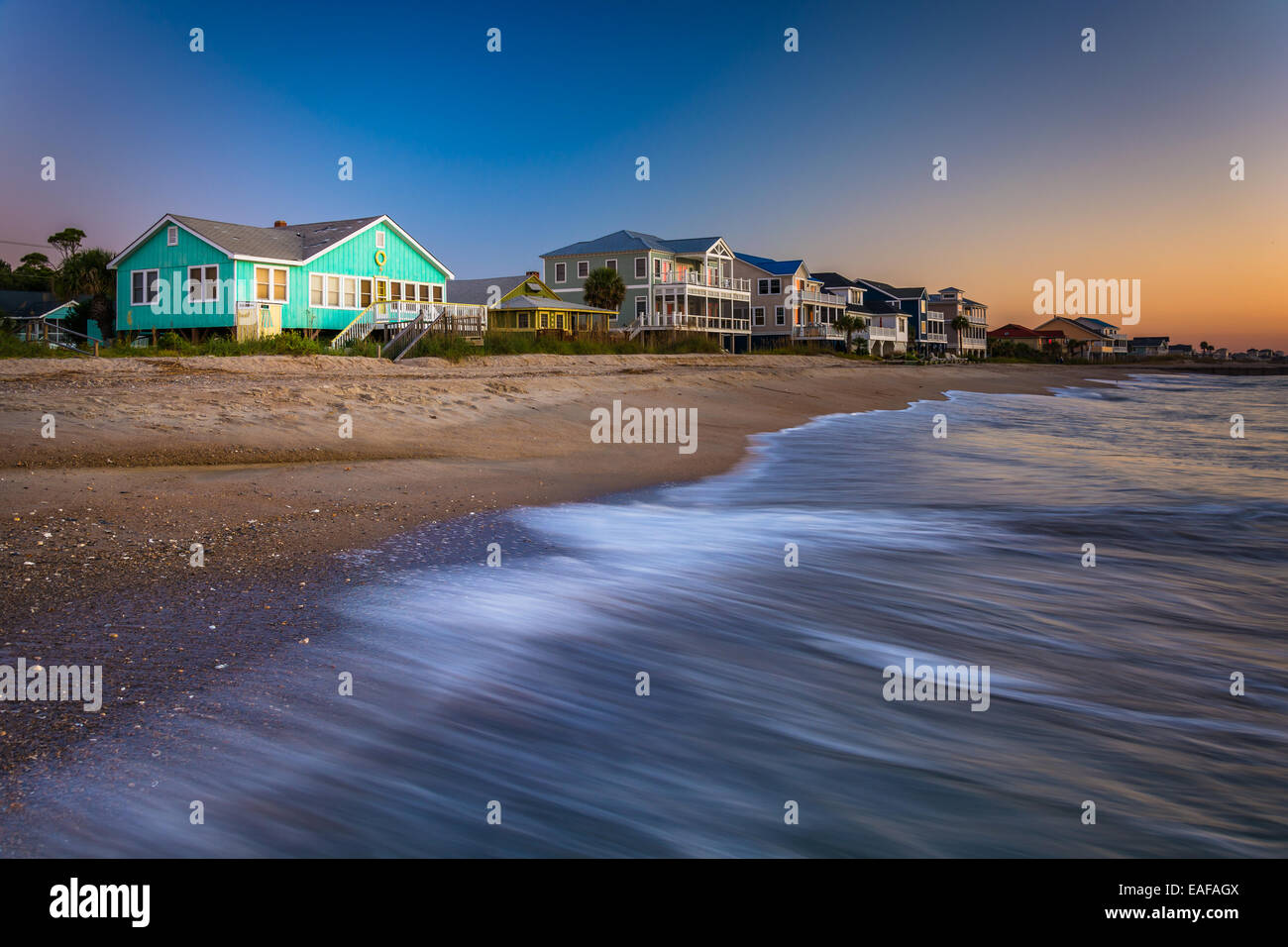 Wellen in den Atlantischen Ozean und am Strand Häuser bei Sonnenaufgang, Edisto Beach, South Carolina. Stockfoto