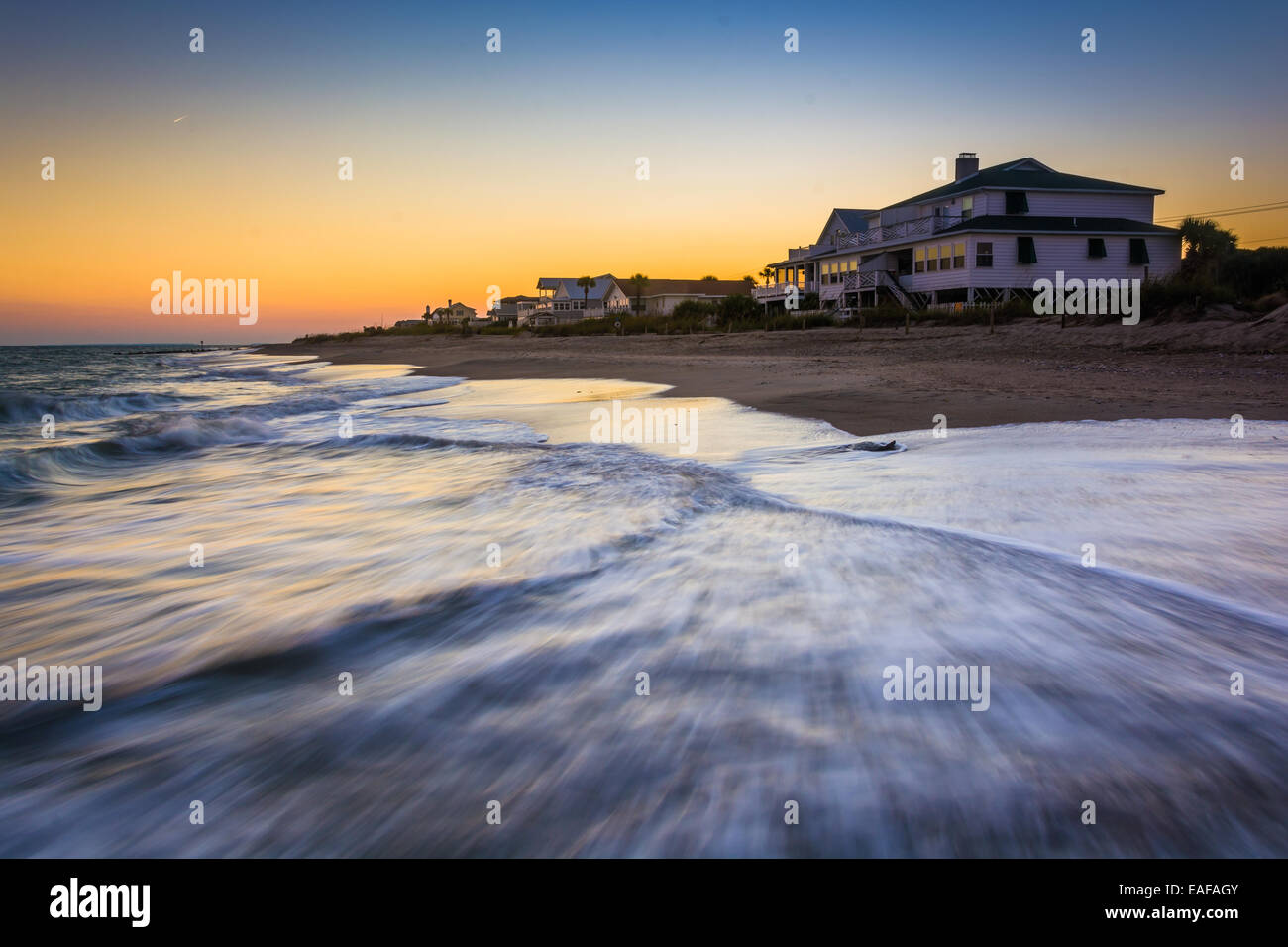 Wellen in den Atlantischen Ozean und am Strand Häuser bei Sonnenuntergang, Edisto Beach, South Carolina. Stockfoto