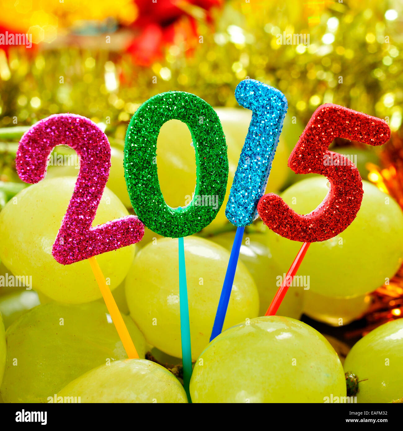 Zahlen in verschiedenen Farben bilden die Zahl 2015, als das neue Jahr mit einem Haufen von Trauben im Hintergrund Stockfoto