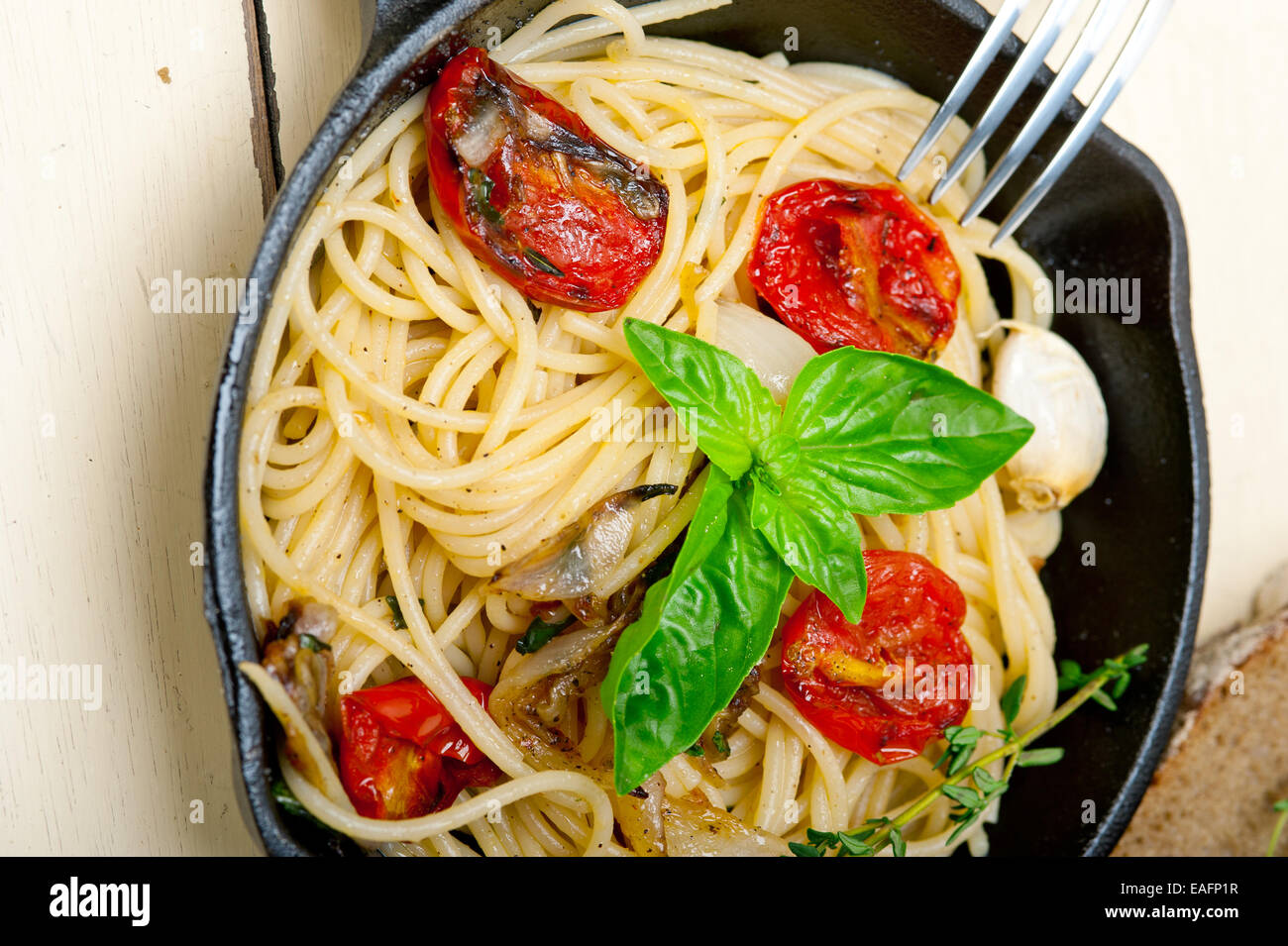 italienische Spaghetti Nudeln mit gebackenen Tomaten Basilikum und Thymian Sauce auf einer gusseisernen Pfanne Stockfoto