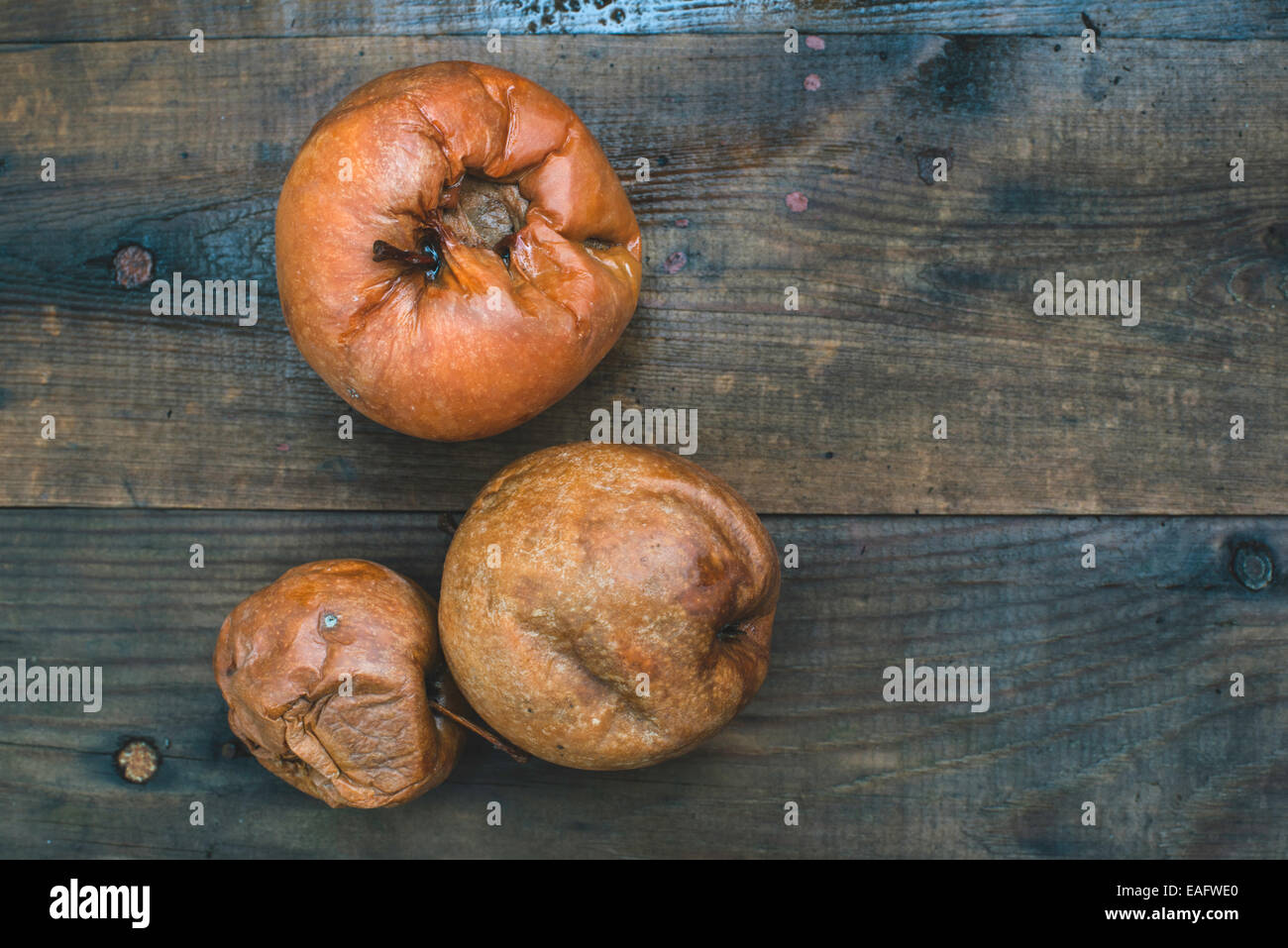 Faule Äpfel auf Holz. Tageslicht Stockfoto