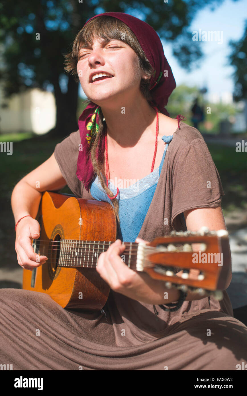 Mädchen spielt Gitarre auf der Straße. Sonnigen Tag Stockfoto