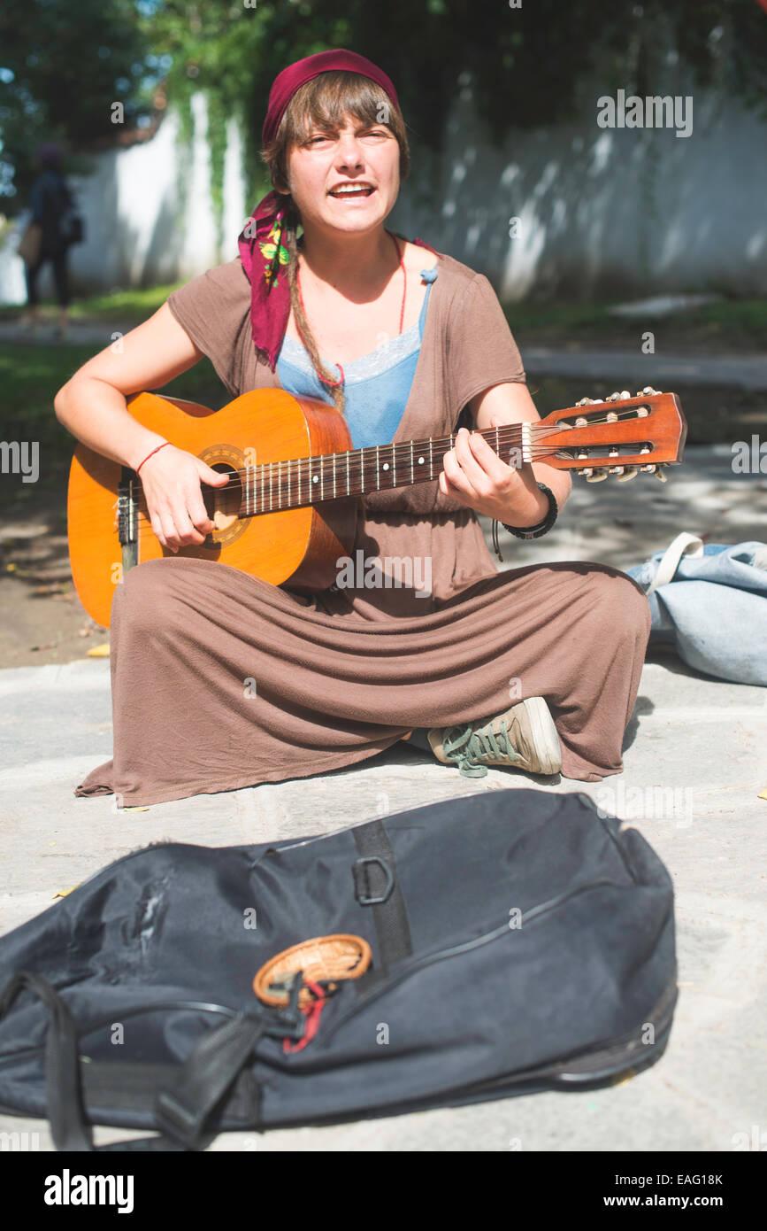 Mädchen spielt Gitarre auf der Straße. Sonnigen Tag Stockfoto