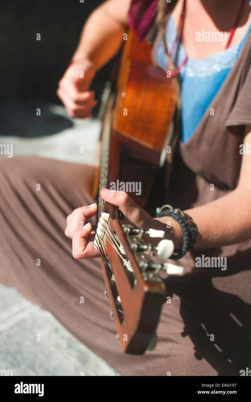 Mädchen spielt Gitarre auf der Straße. Sonnigen Tag Stockfoto