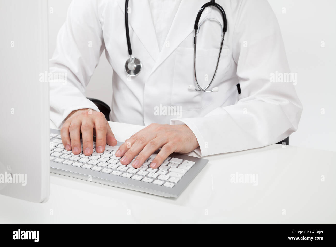 Arzt, die Eingabe auf Computer in Arztpraxis Stockfoto