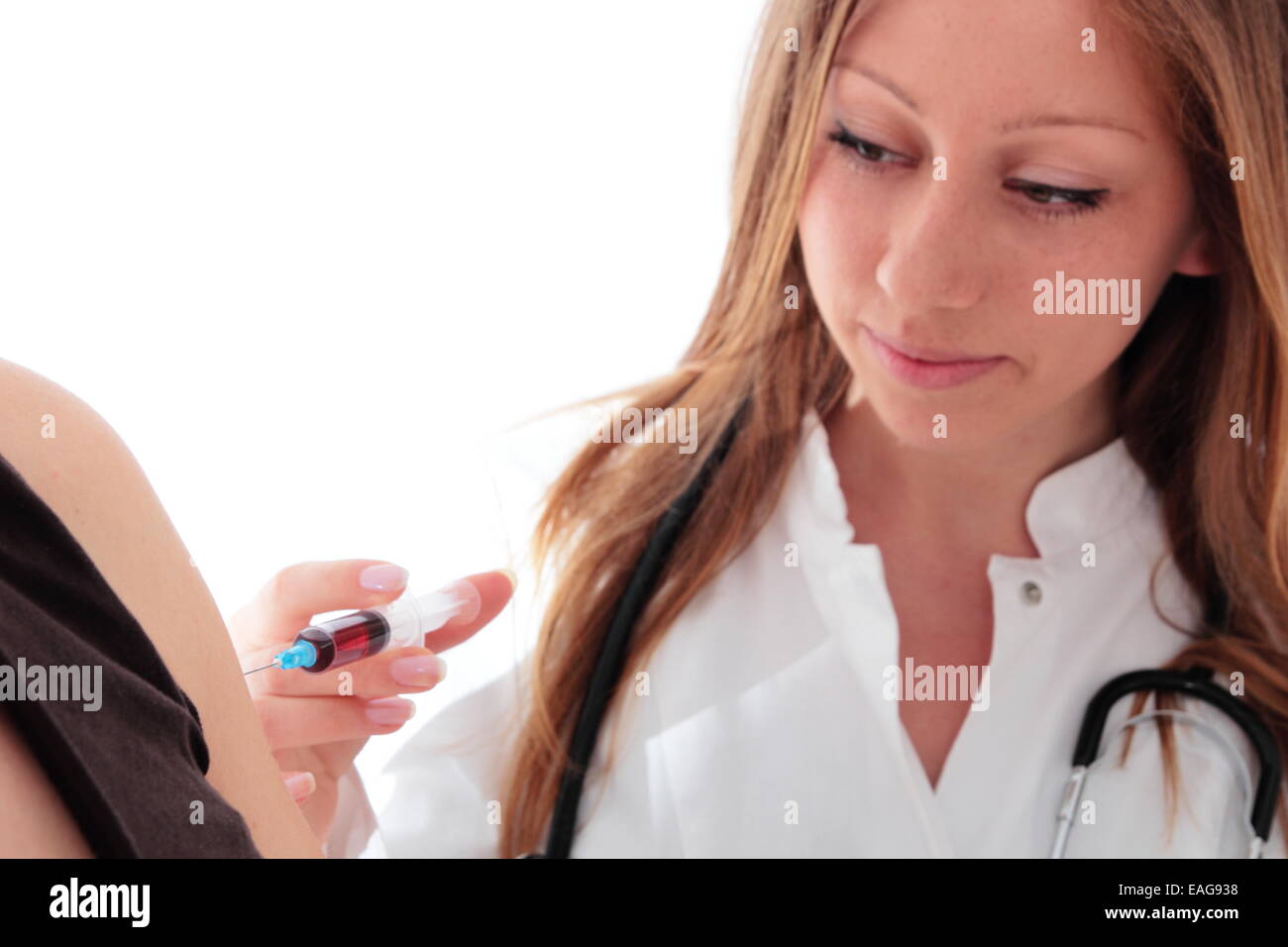 Eine Ärztin mit Spritze tut eine Impfung Stockfoto