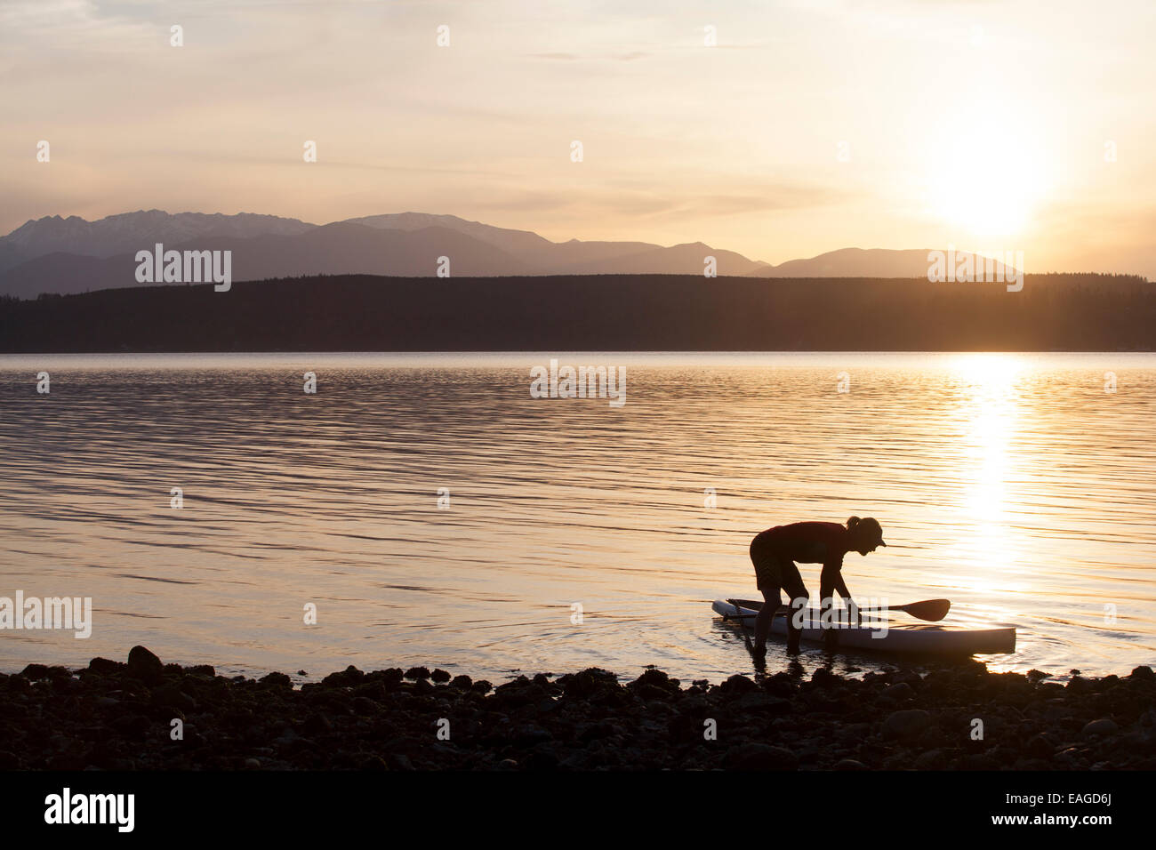 Ein Mann legt seine Stand-up Paddle Board auf dem Puget Sound in der Nähe von Poulsbo, Washington. Stockfoto