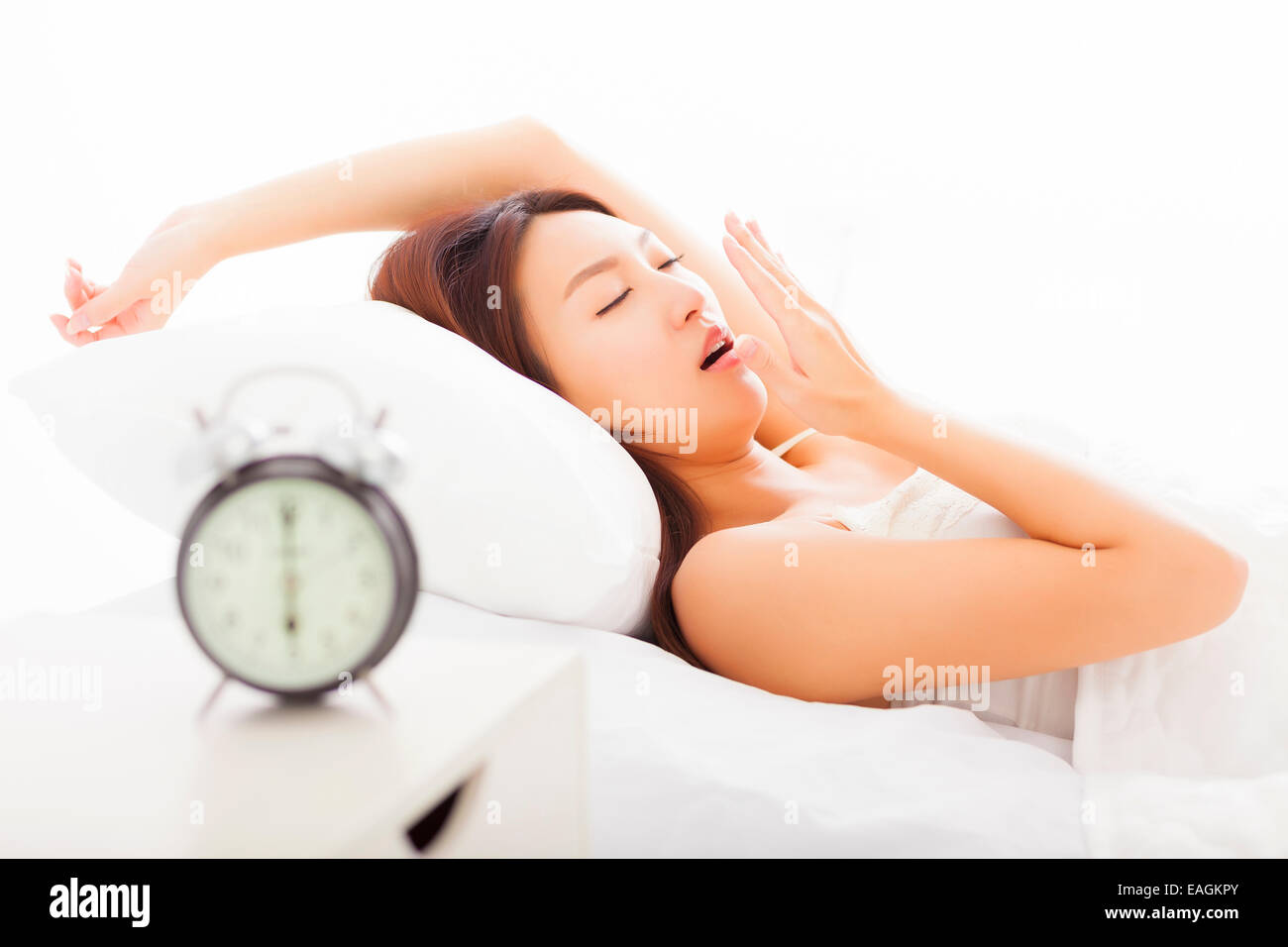 junge Frau Gähnen und schlafend im Bett Stockfoto