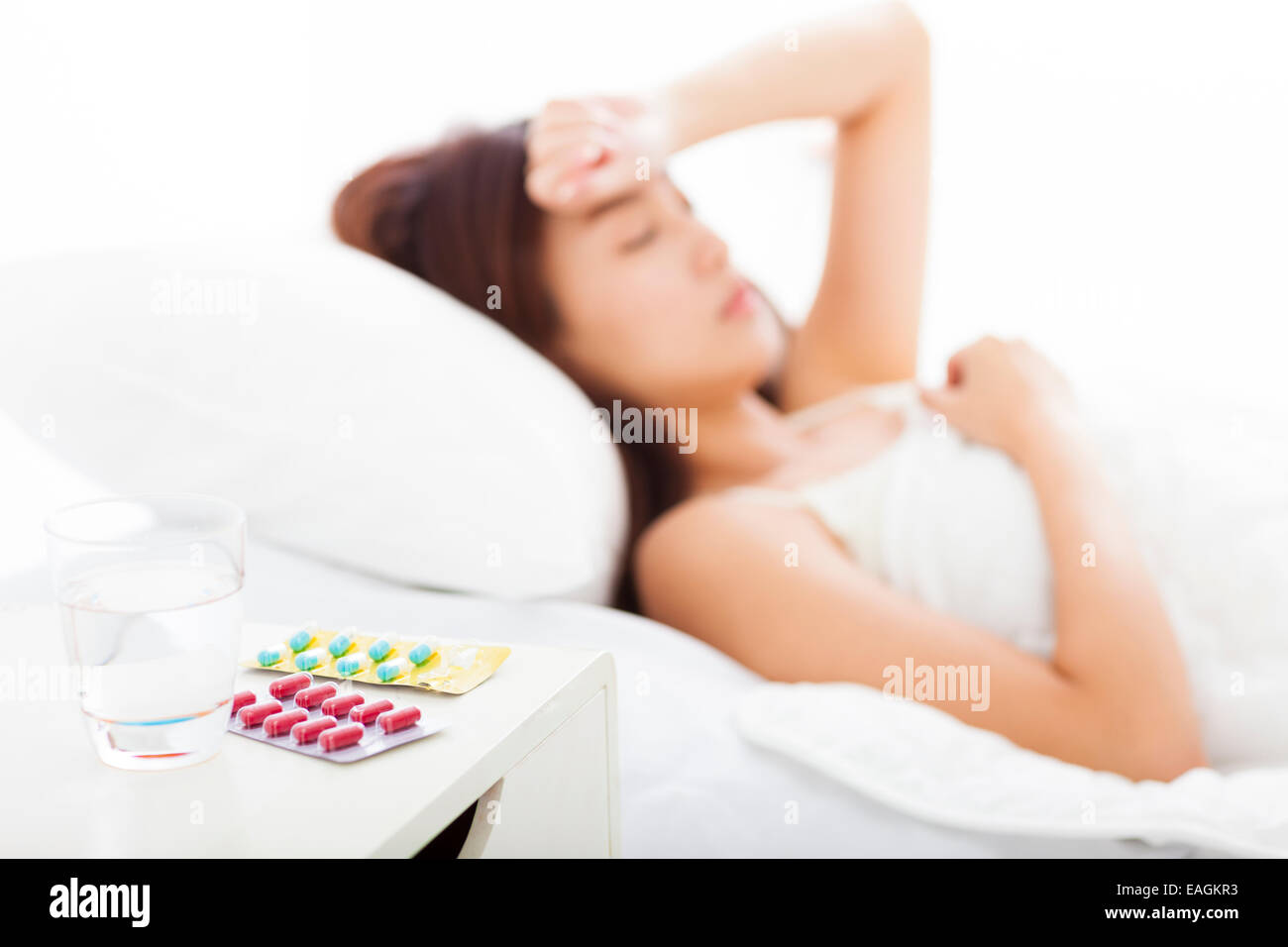 Medikamente und Wasser vor, fing Frau kalt schlafen im Bett Stockfoto