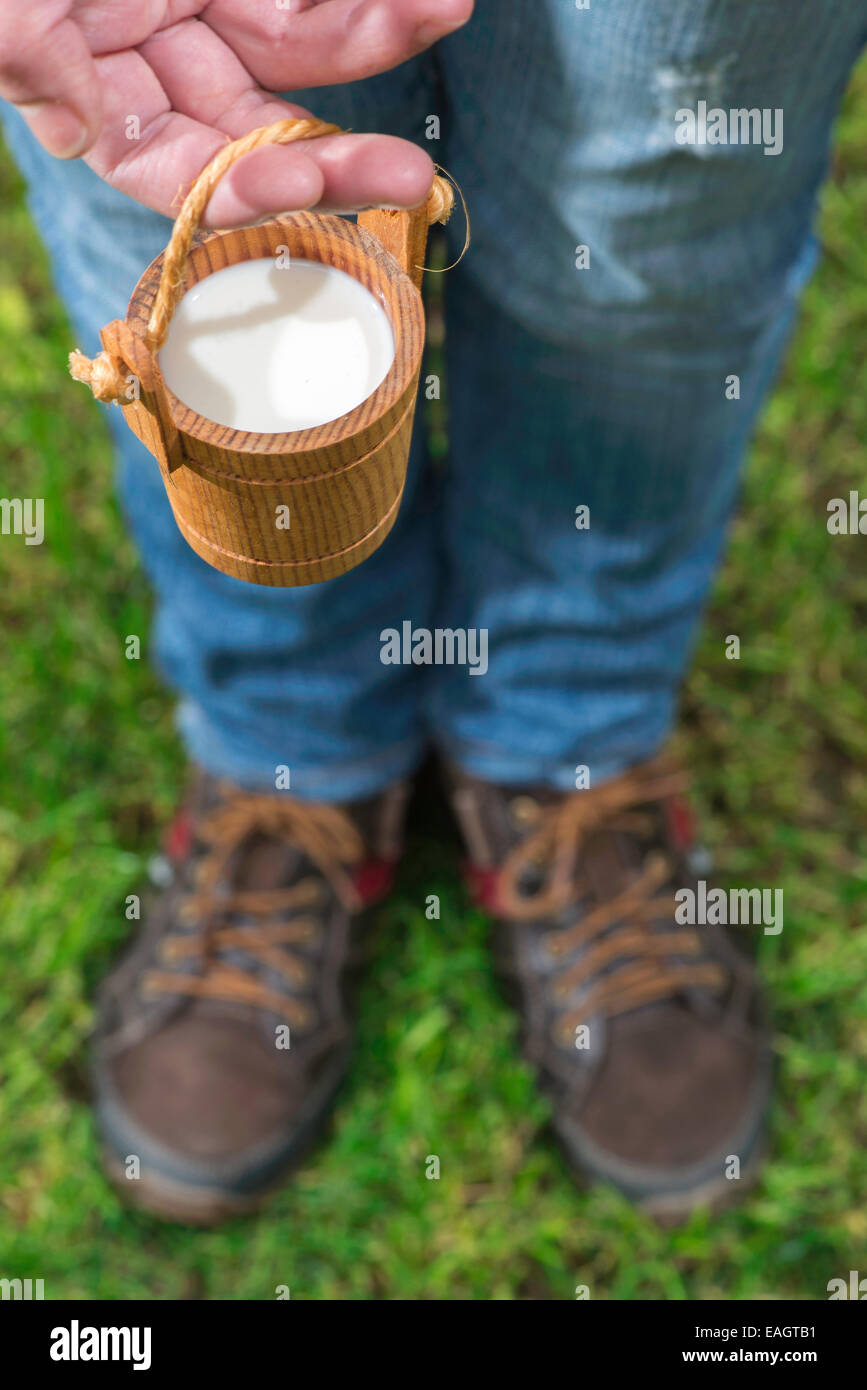 Frauen halten kleine hölzerne Becher Milch Stockfoto