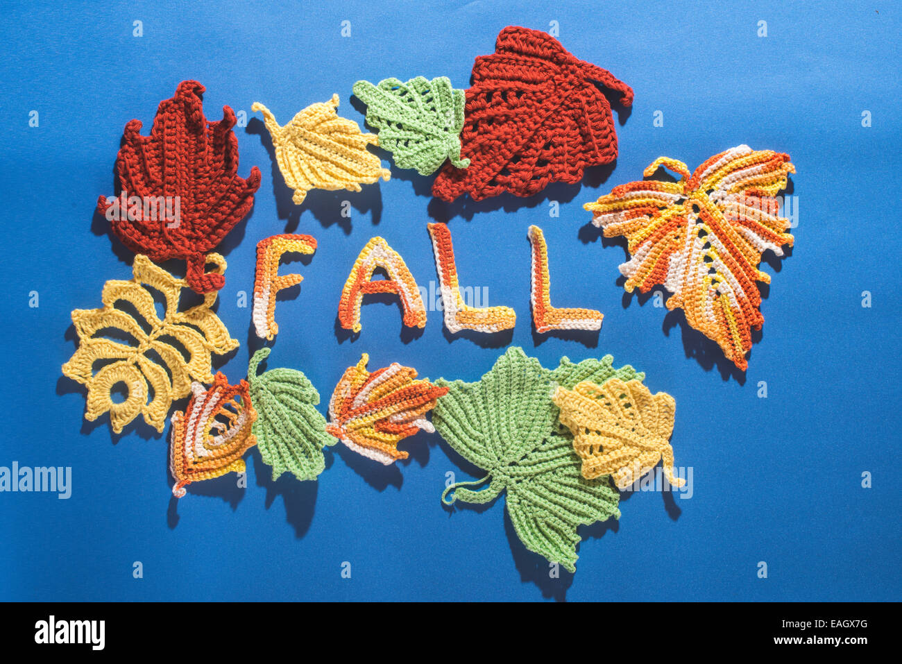 Gestrickte Herbstlaub auf blau Textil Stockfoto