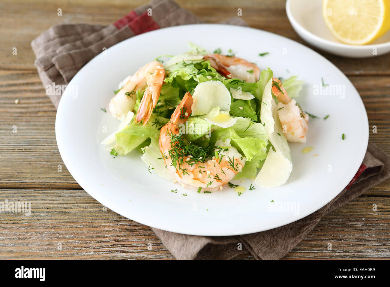 Salat mit Garnelen, Salat und Käse auf einem weißen Teller auf einem boards Stockfoto