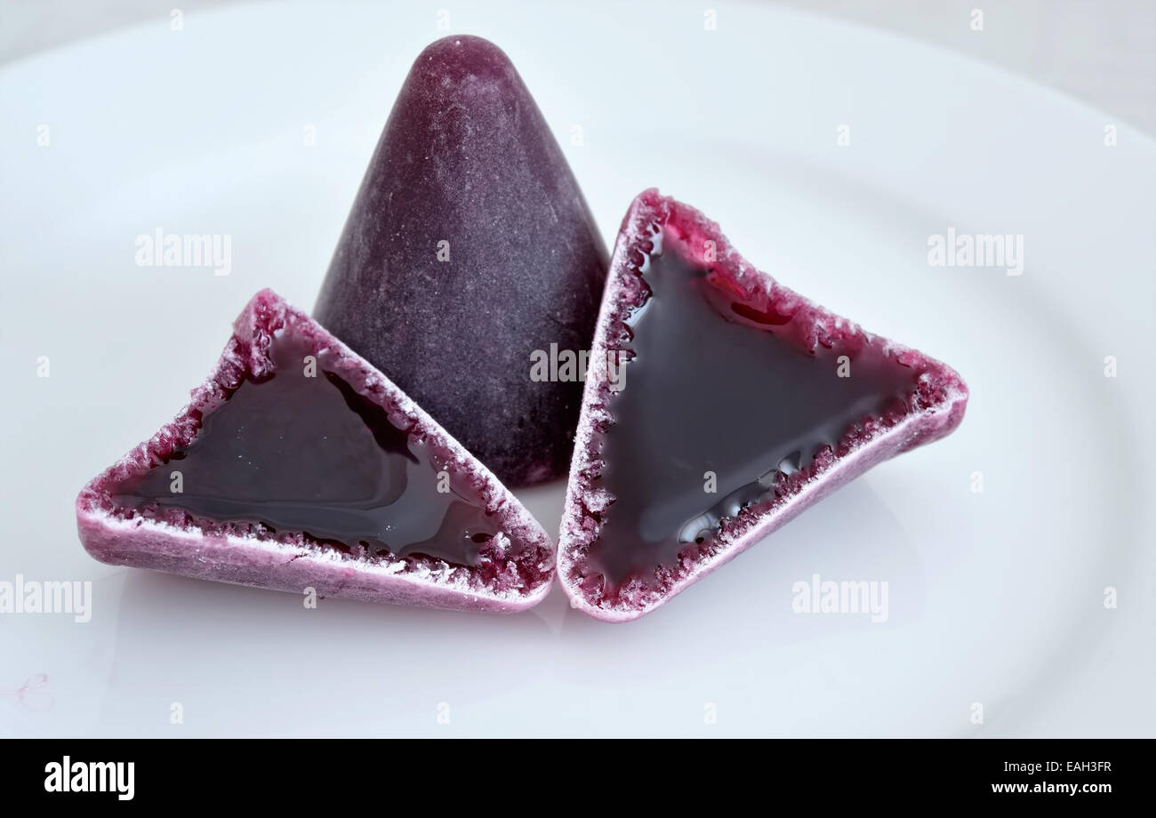 Lila traditionelle belgische Pralinen Cuberdons auf einem weißen Teller Stockfoto