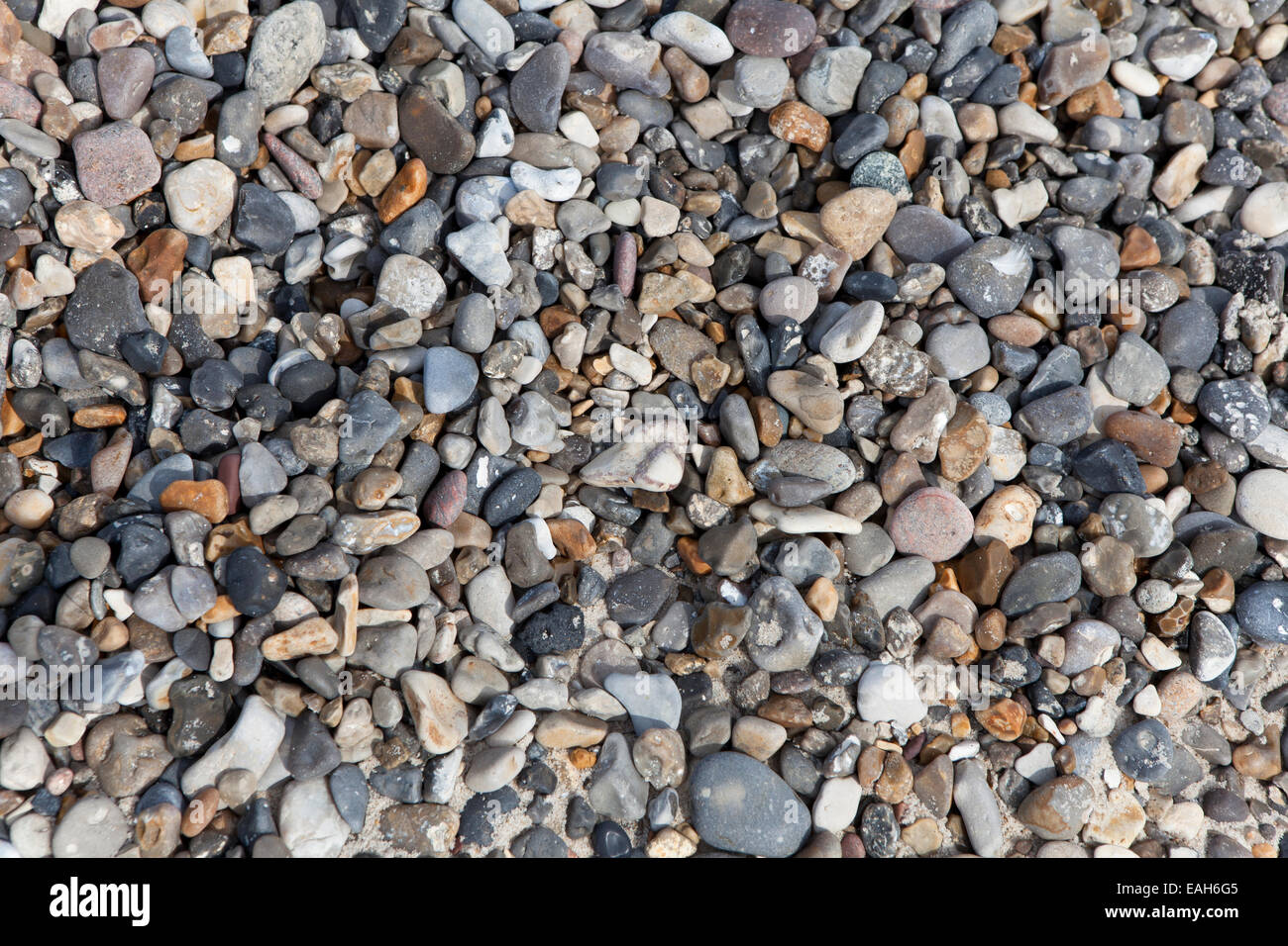 verschiedene bunte Kieselsteine am Strand Hintergrund Stockfoto