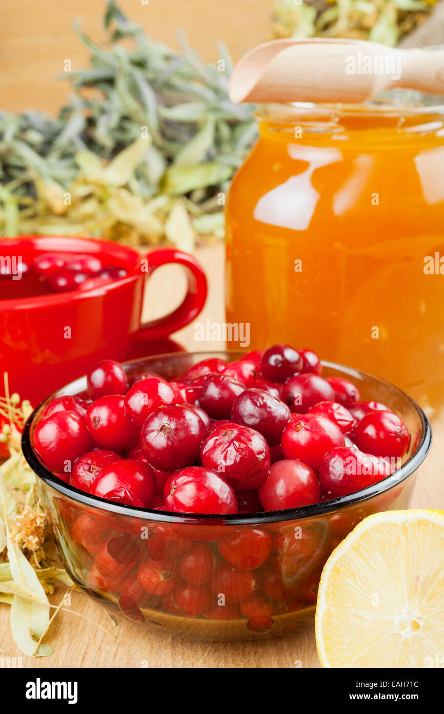 Preiselbeeren, Glas mit Honig, Obst Teetasse, Heilkräuter und Zitrone Stockfoto