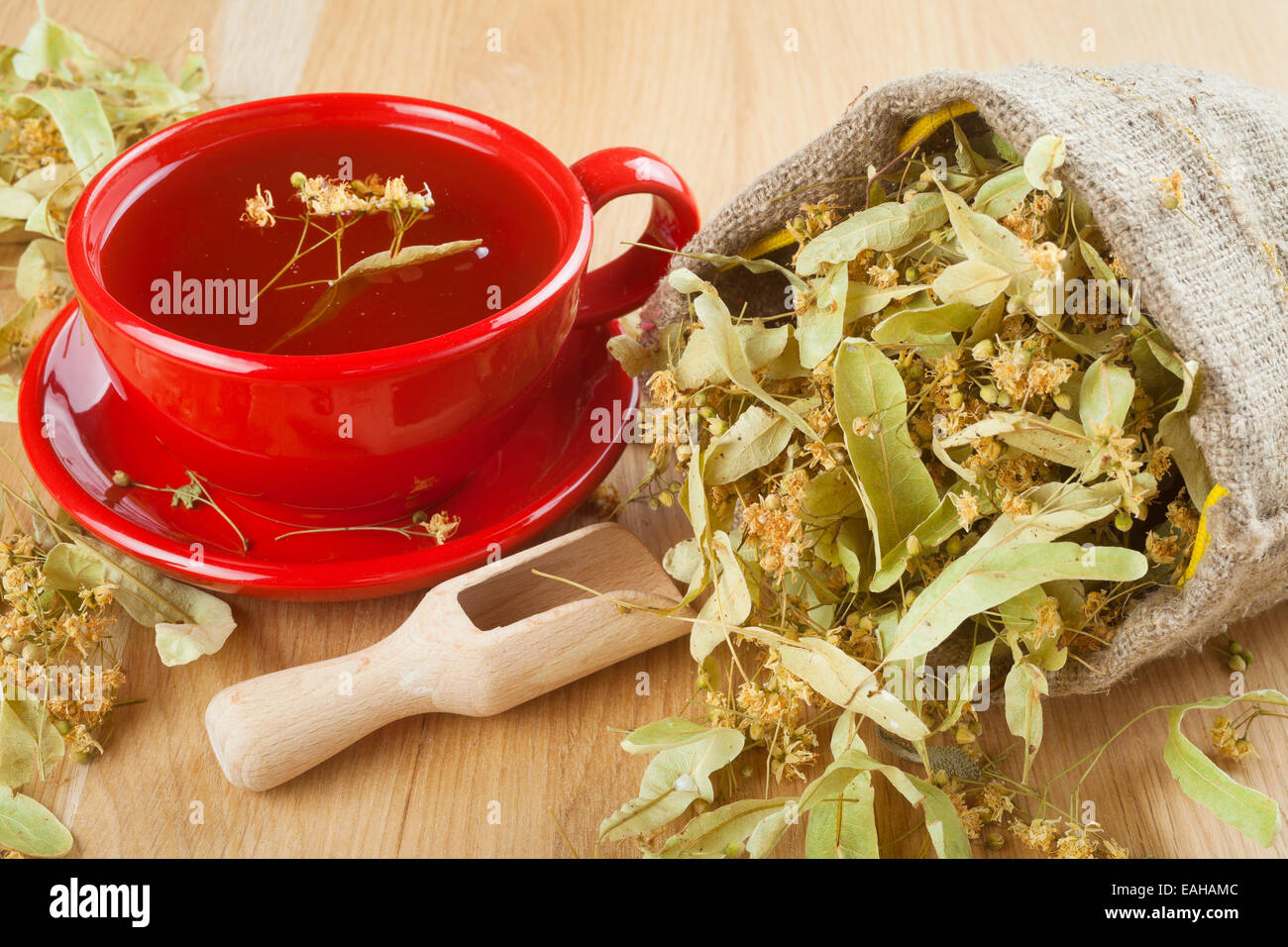 Linden Tee und Blumen in Leinentasche auf Holztisch Stockfoto