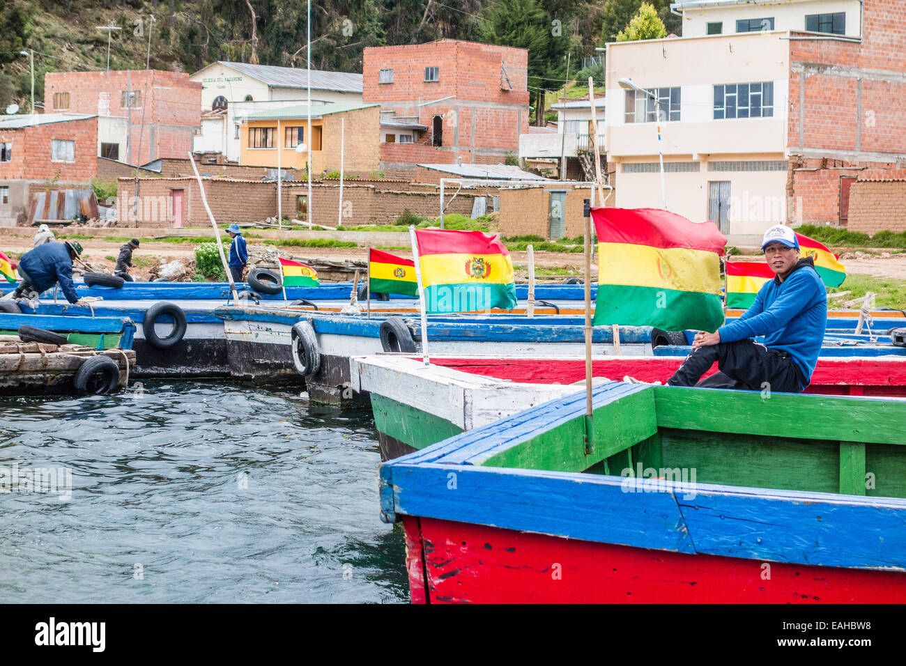 Junger Mann sitzt am Fluss Fähre an der Meerenge von Tiquina, Bolivien. Die Fähren nehmen Autos, LKWs, Busse und Motorräder. Stockfoto