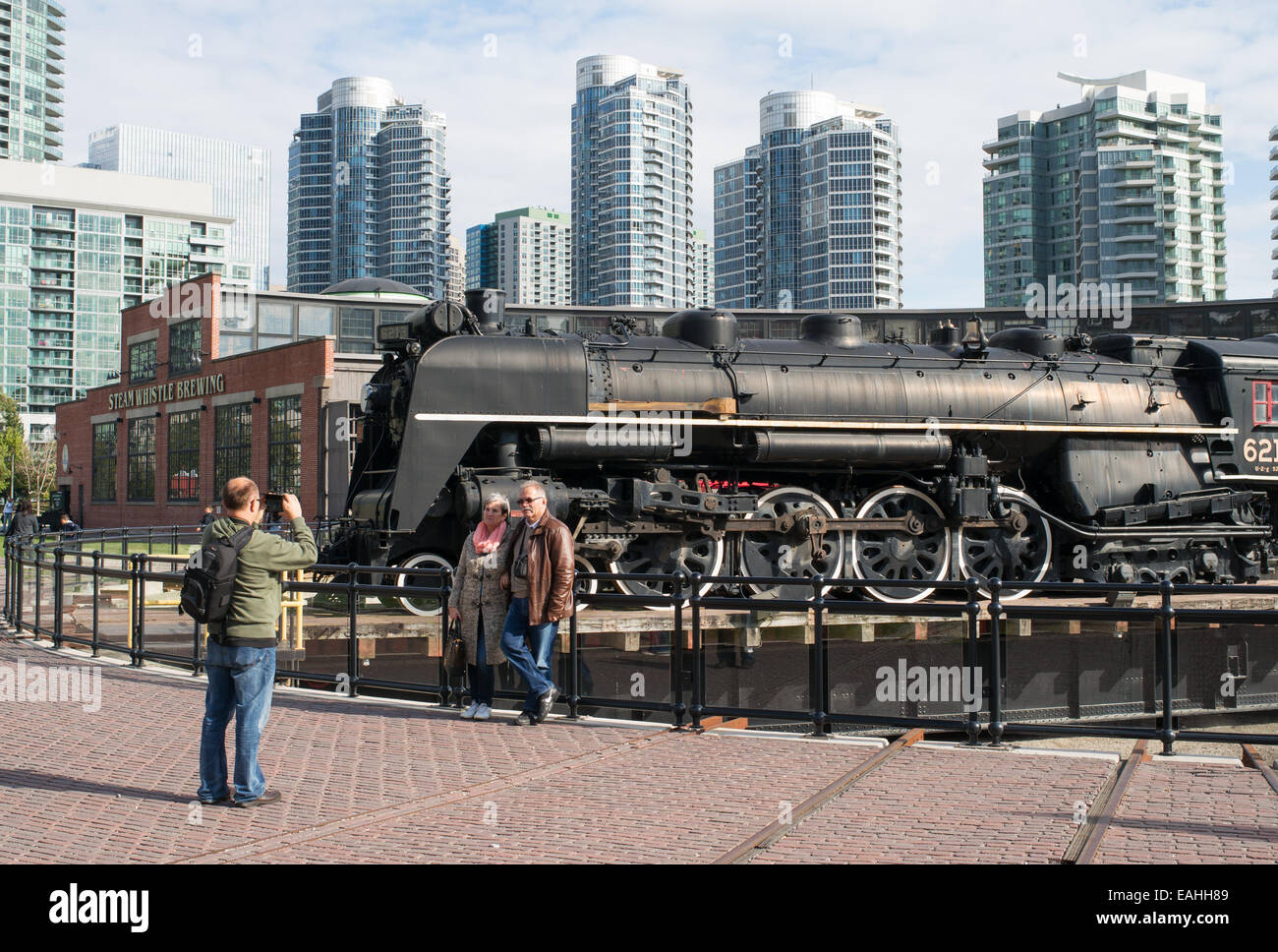 Paar vor Steam Train 6213 auf der Drehscheibe am Ringlokschuppen John Street, Toronto, Ontario, Kanada fotografiert. Stockfoto