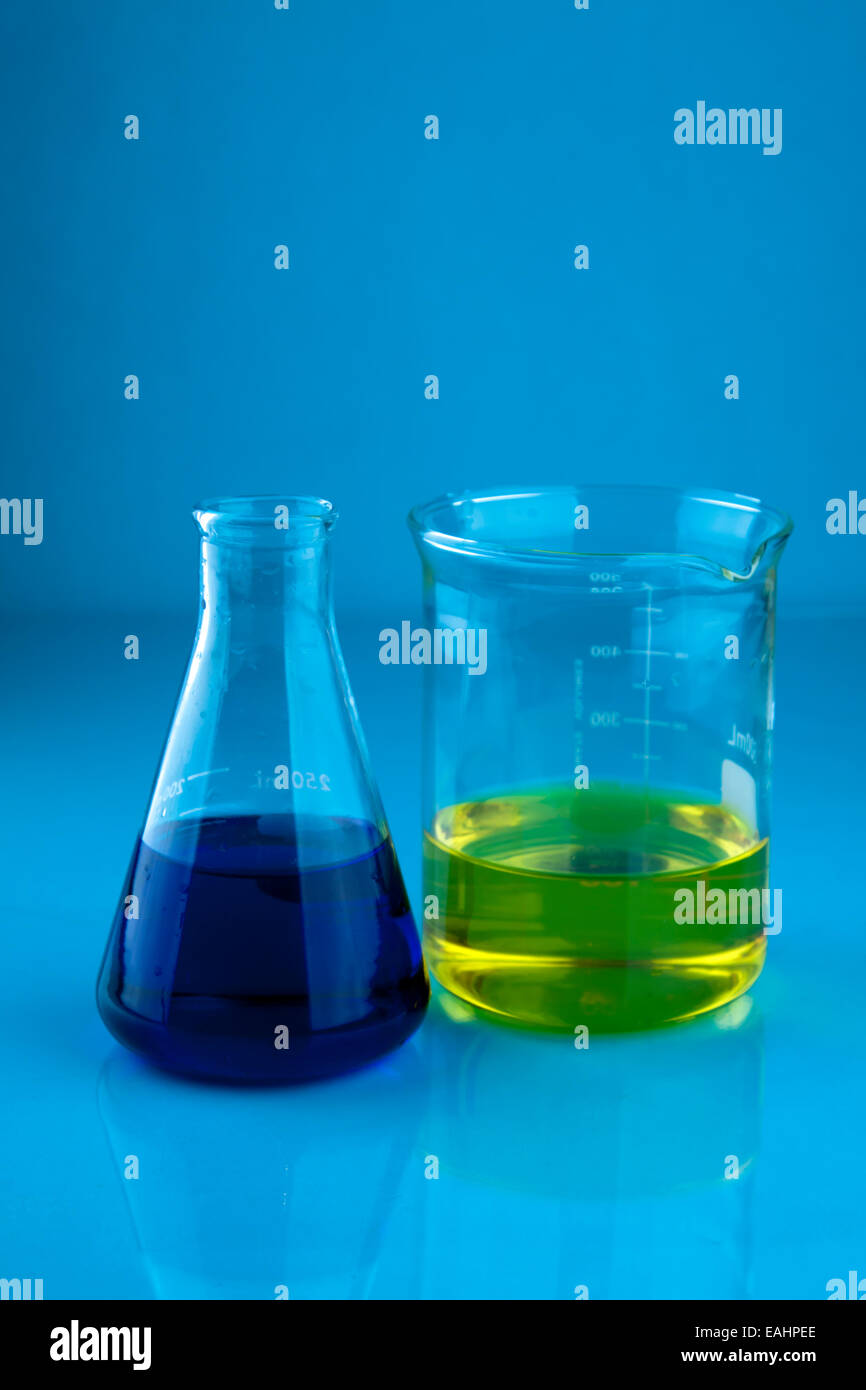 Erlenmeyerkolben mit einer blauen Flüssigkeit und ein Becherglas mit einer gelben Flüssigkeit Stockfoto