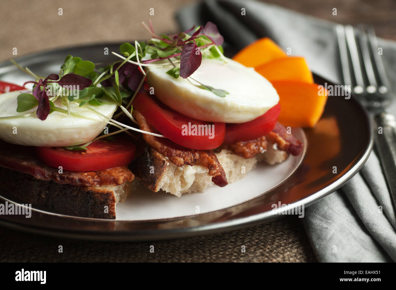 Bunte offen konfrontiert Frühstücks-Sandwich mit Speck, Tomaten, Spiegelei und Sprossen auf frischem Landbrot Stockfoto