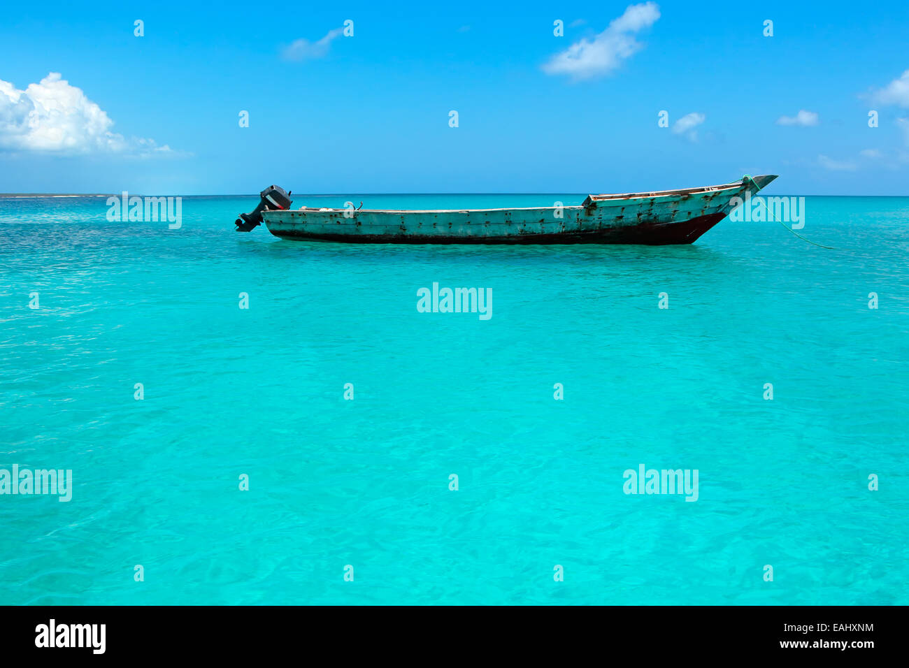 Holzboot, schwimmend auf dem klaren, türkisfarbenen Wasser der Insel Sansibar Stockfoto