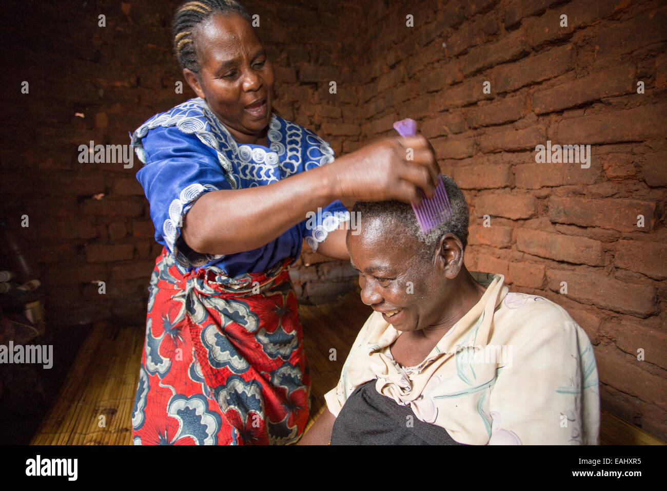 Eine Frau sorgt für einen älteren kranken Patienten zu Hause in Mulanje Bezirk, Malawi. Stockfoto