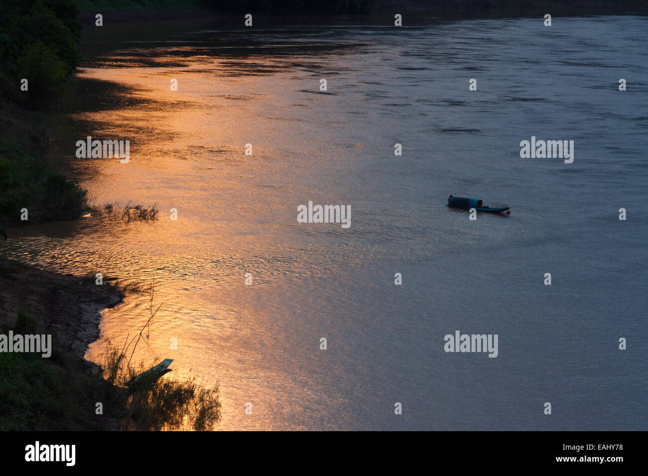 Ein einsamer Boot am Fluss Nam Ou in Laos als Sonnenuntergang Stockfoto