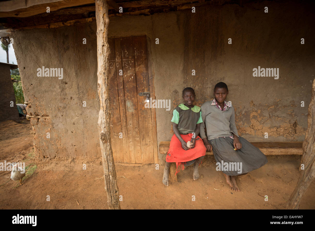 Zwei Mädchen sitzen zusammen auf einer Veranda in Bukwo District, Uganda, Ostafrika. Stockfoto