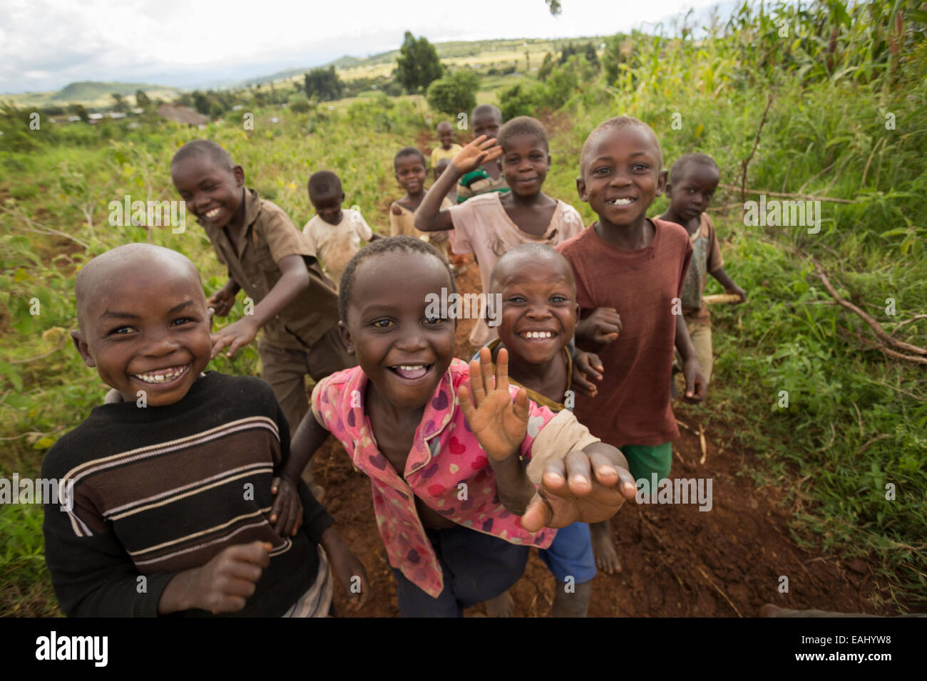 Glückliche Kinder laufen zusammen auf einer ländlichen Straße in Bukwo District, Uganda. Stockfoto