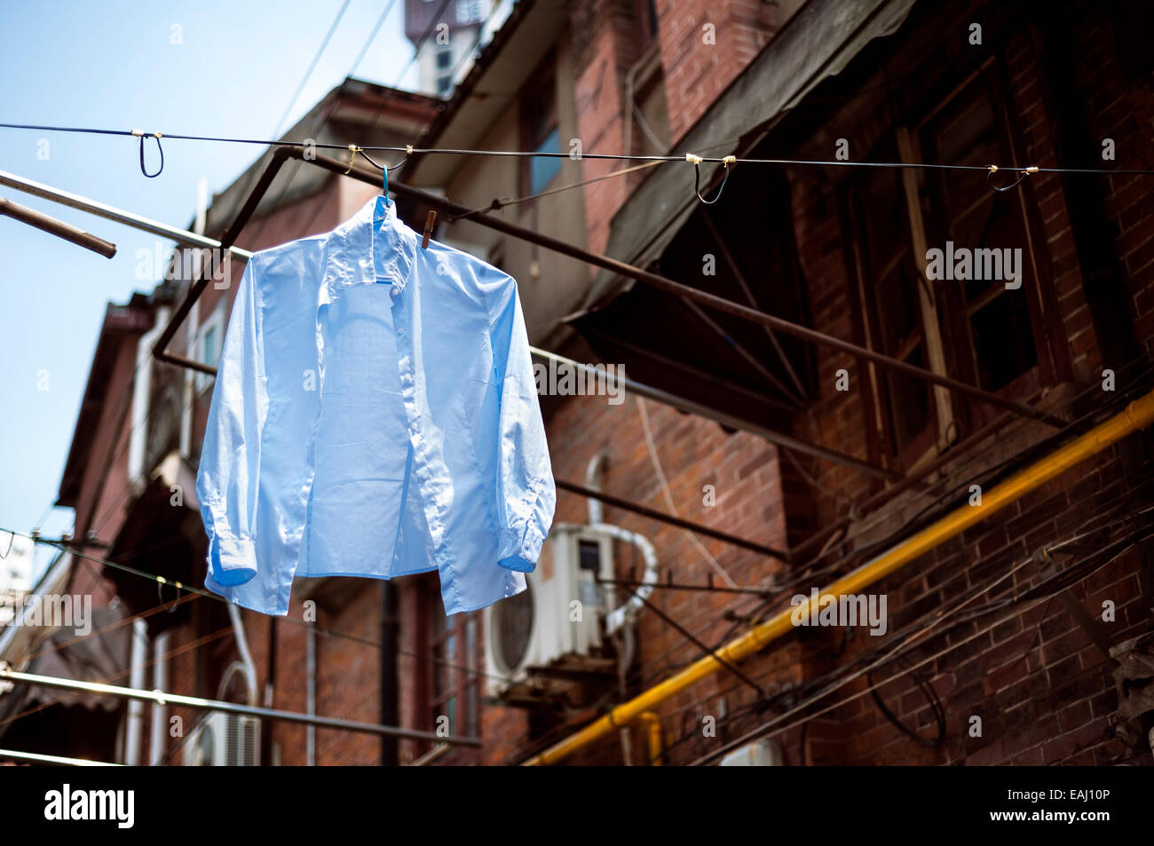 Blaues Hemd hängt eine Wäscheleine in einer traditionellen Gasse in der Altstadt von Shanghai Stockfoto