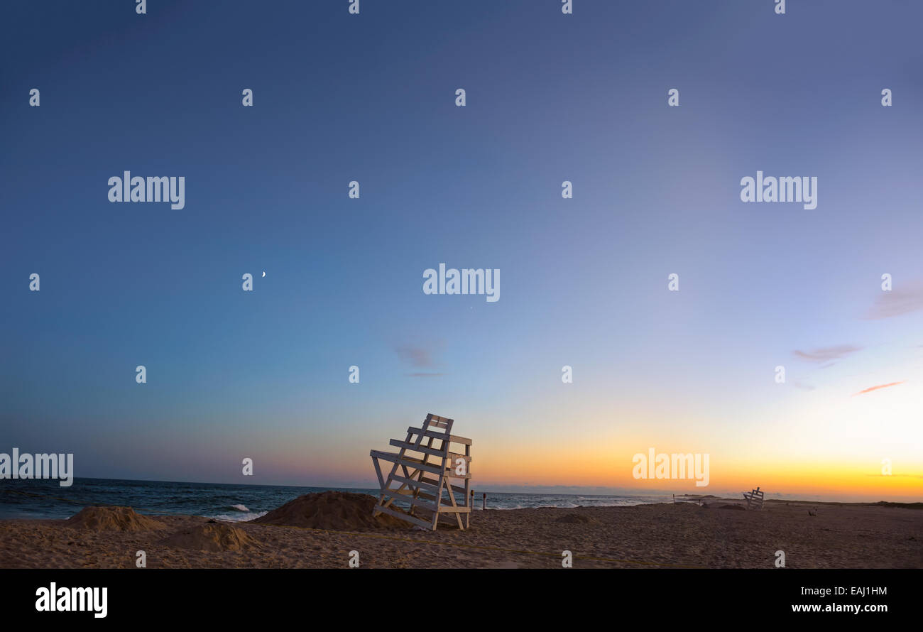 Sommer in den Hamptons. Ponquogue Strand, Hampton Bays, New York blaue Stunde Sonnenuntergang Rettungsschwimmer Stühle, Splitter von dem Mond, Venus. Stockfoto