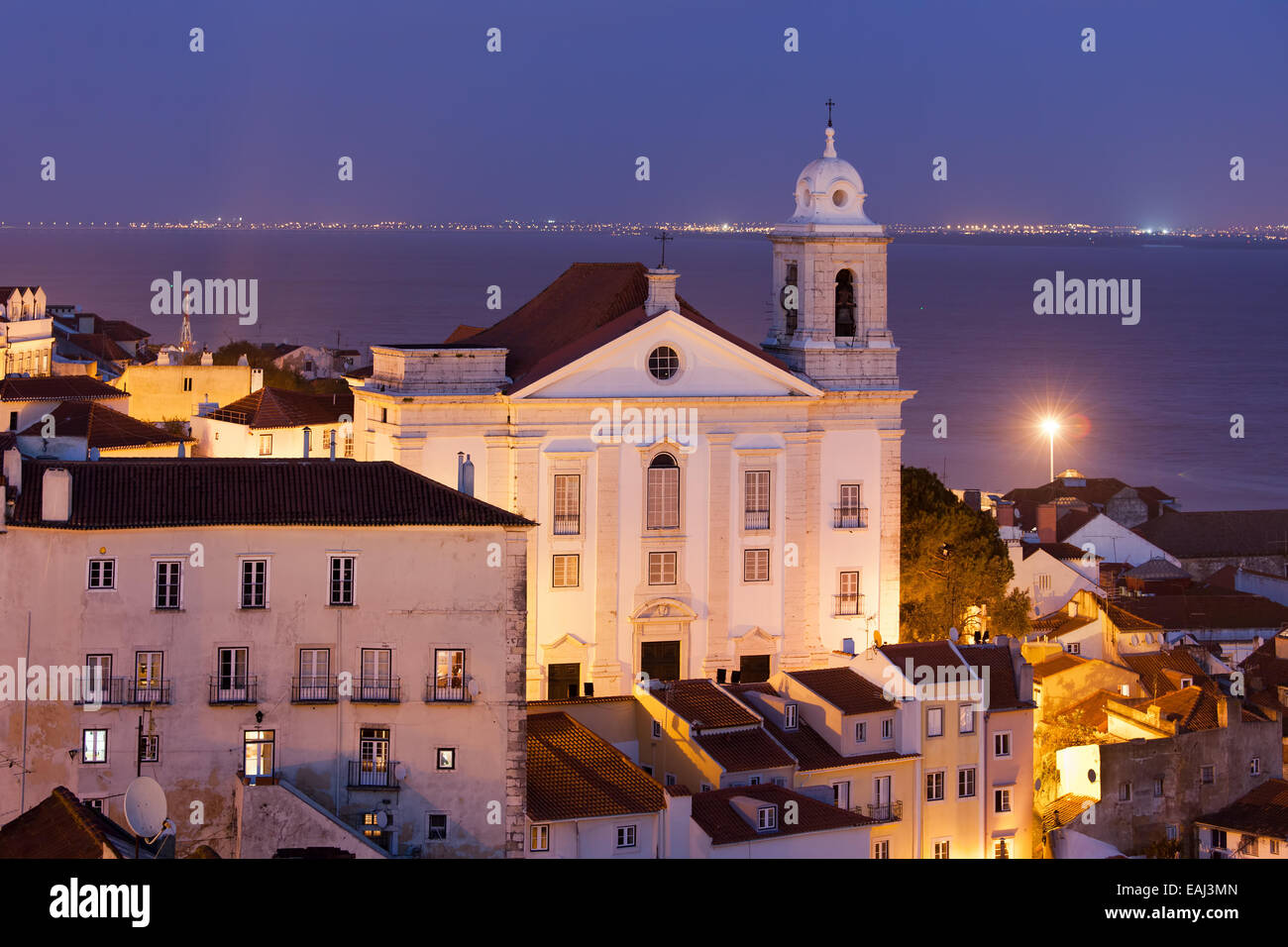 Santo Estevao Kirche nachts im alten Alfama Viertel von Lissabon in Portugal, Tejo im Hintergrund. Stockfoto