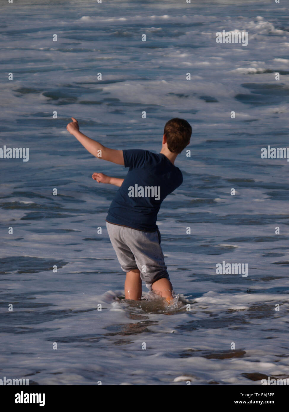 Junge skimming Steinen im Meer, Bude, Cornwall, UK Stockfoto