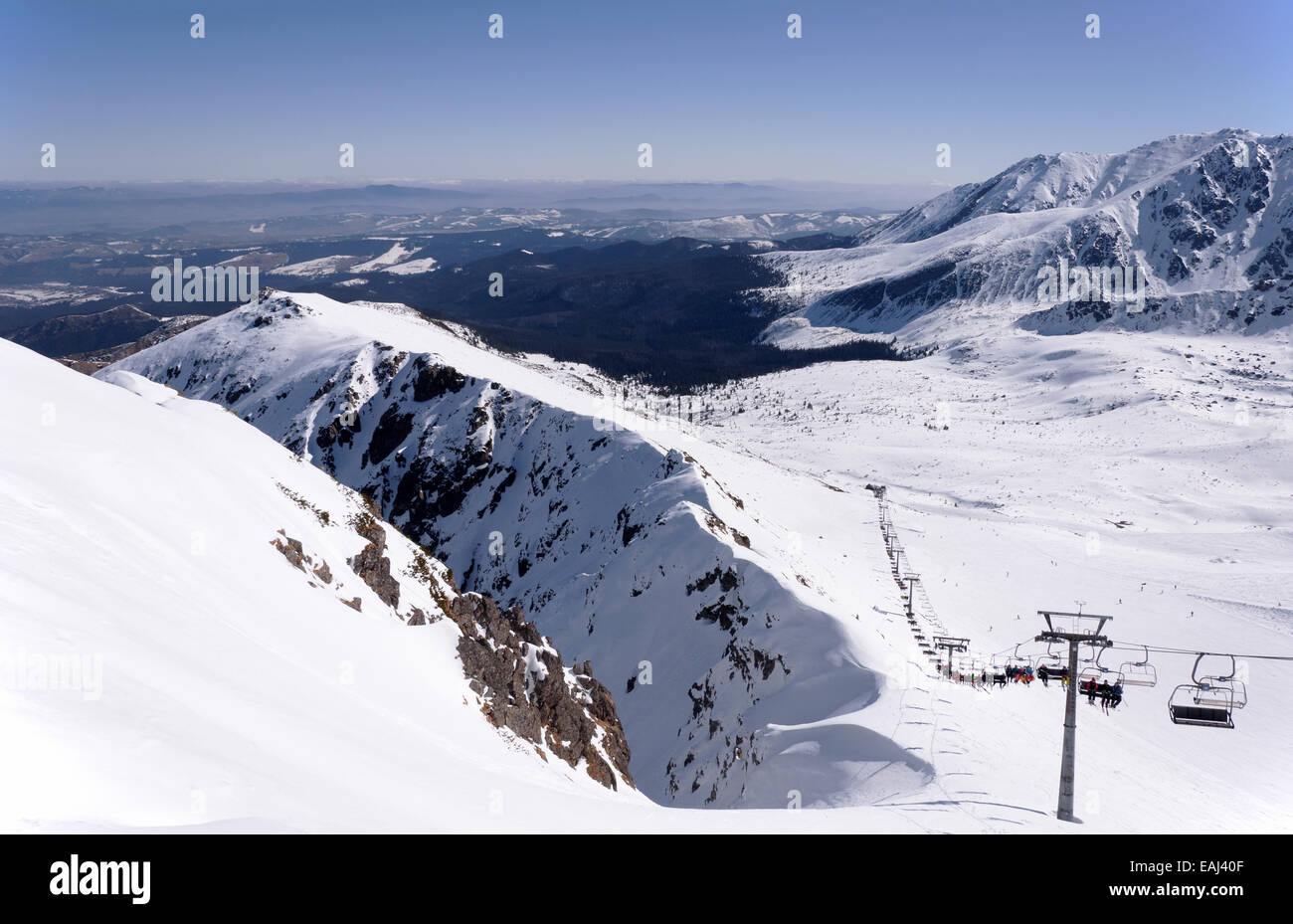 Skipisten und Sessellift auf Hala Gasienicowa im Tatra-Gebirge in Polen mit den weit Blick der Region Podhale. Stockfoto
