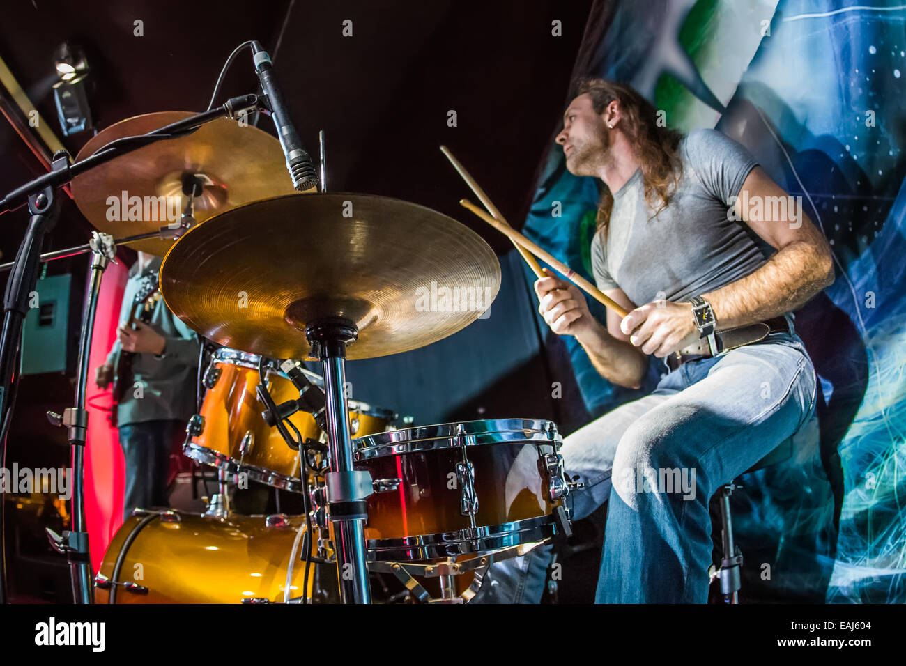 Schlagzeuger (Fokus auf der Trommel und Mikrofon) auf Schlagzeug auf der Bühne zu spielen. Stockfoto