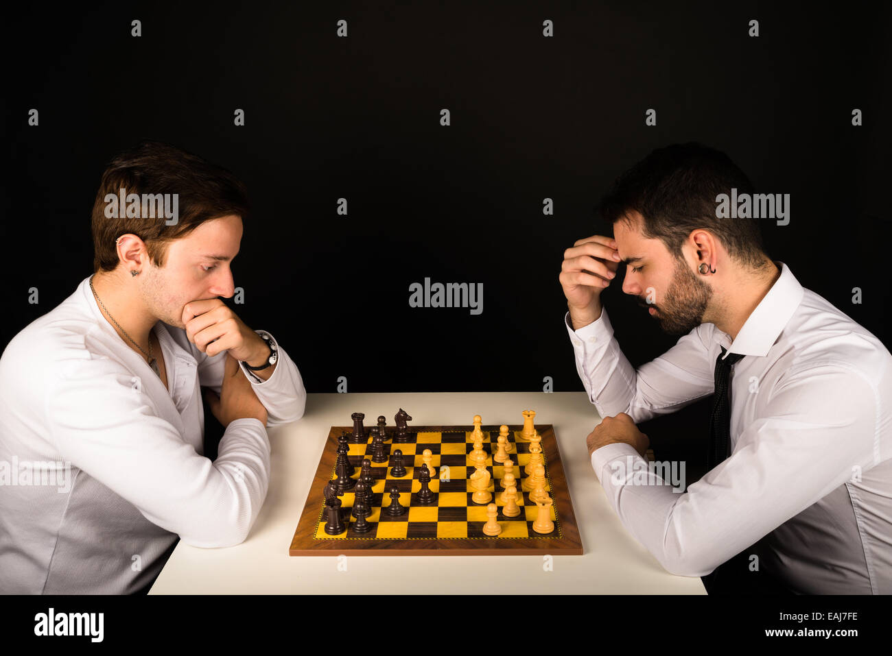 Zwei Jungs in ihren 20ern konzentriert spielt Schach Stockfoto