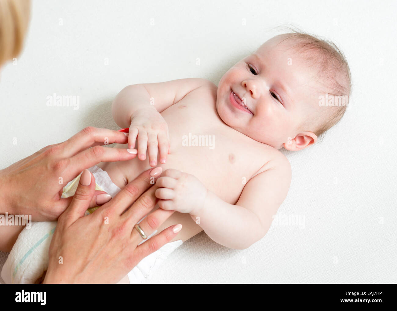 Baby-Massage. Mutter Baby Bauch massieren Stockfoto