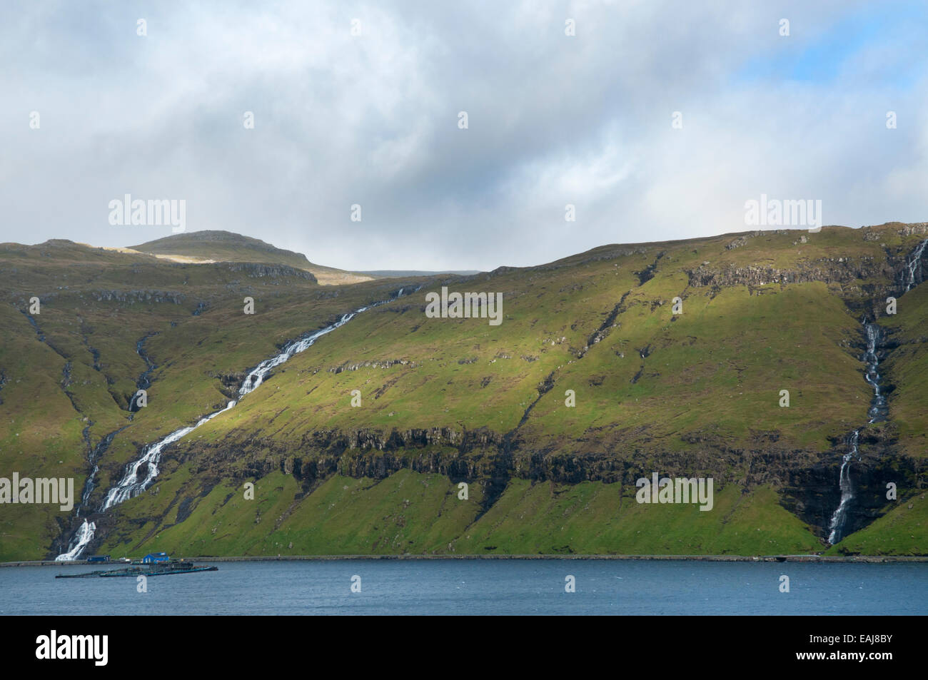 Zwei Wasserfälle, die bis in den Ozean von steilen Hängen, Färöer Inseln Stockfoto