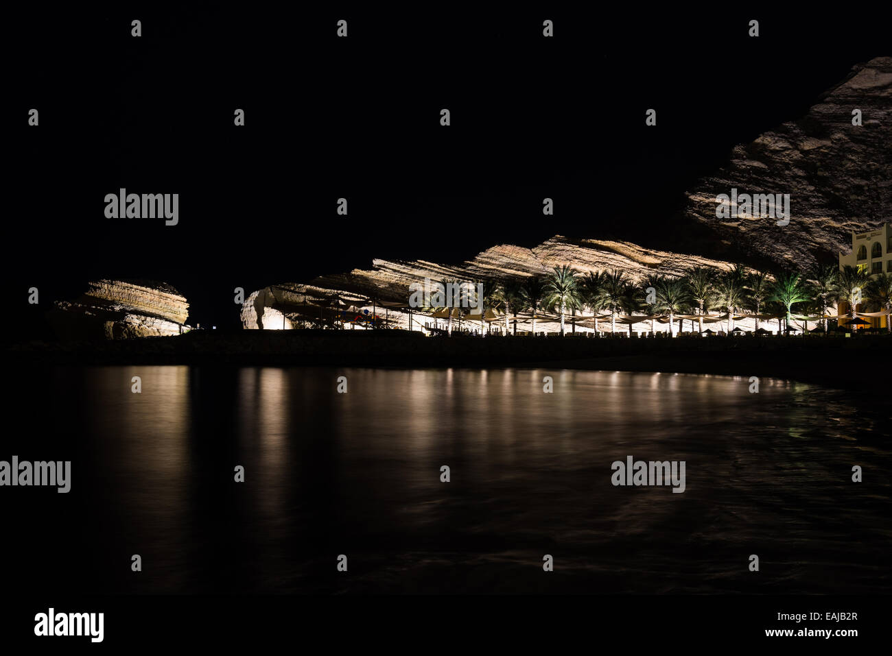 Kalksteinfelsen beleuchtet in der Nacht in einem Luxus-Resort vom arabischen Meer. Oman. Stockfoto