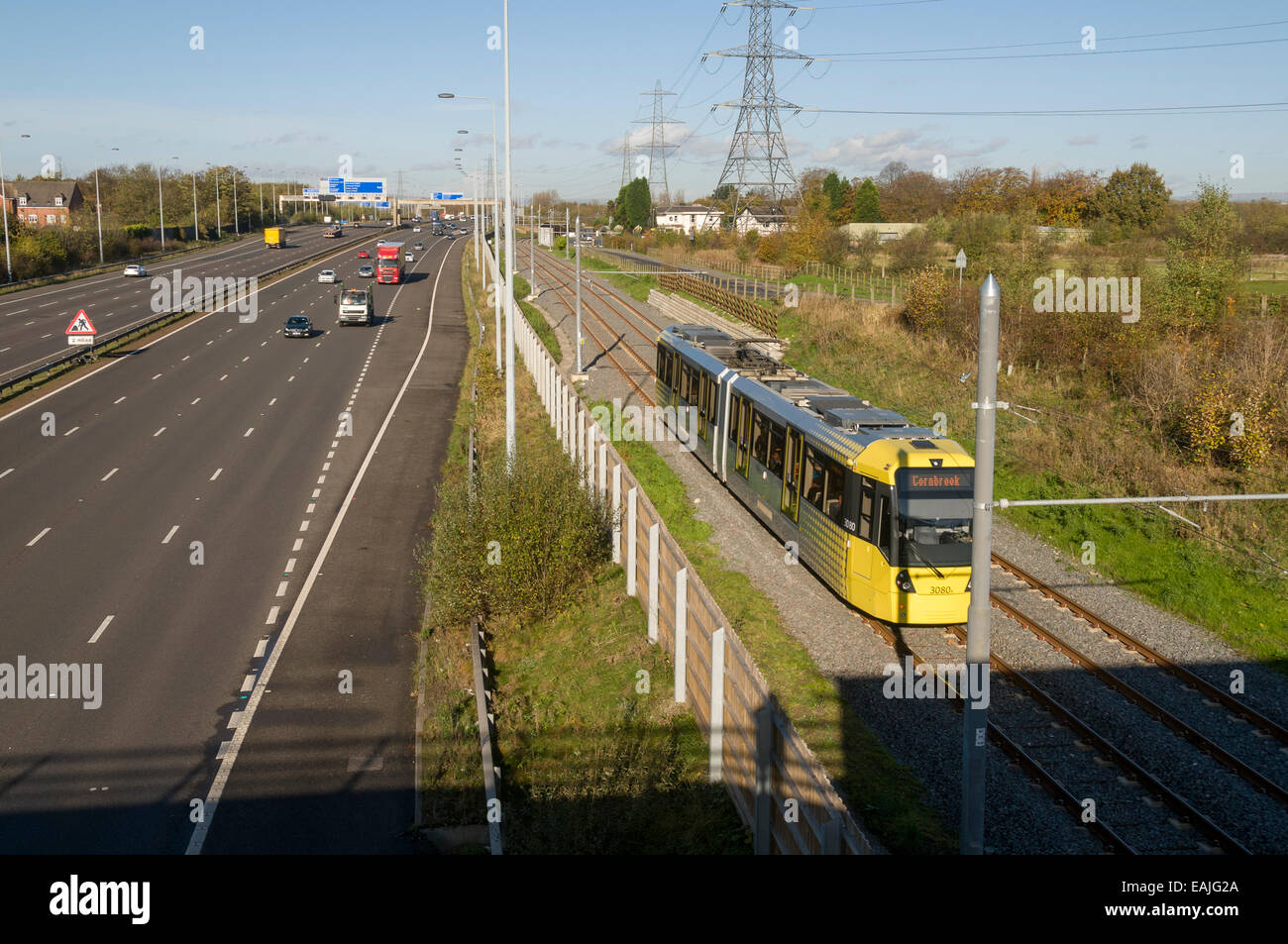 Metrolink tram neben Autobahn M60 auf der Flughafen-Linie, Manchester, England, UK Stockfoto