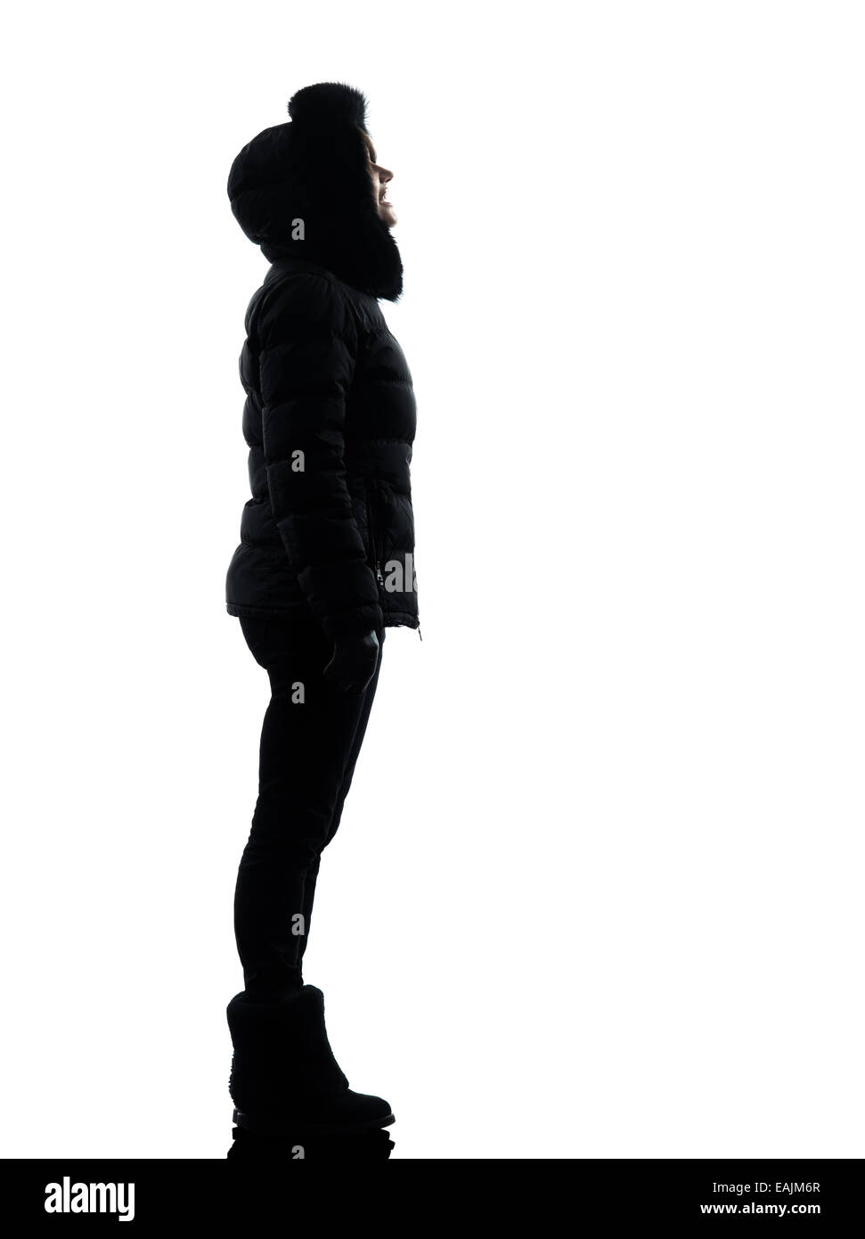 eine Frau im Wintermantel blickte lächelnd Silhouette auf weißem Hintergrund Stockfoto