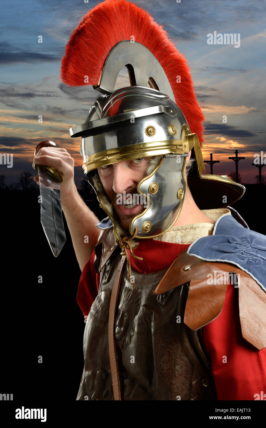 Römischer Soldat mit Schwert und Kalvarienberg mit kreuzt im Hintergrund Stockfoto