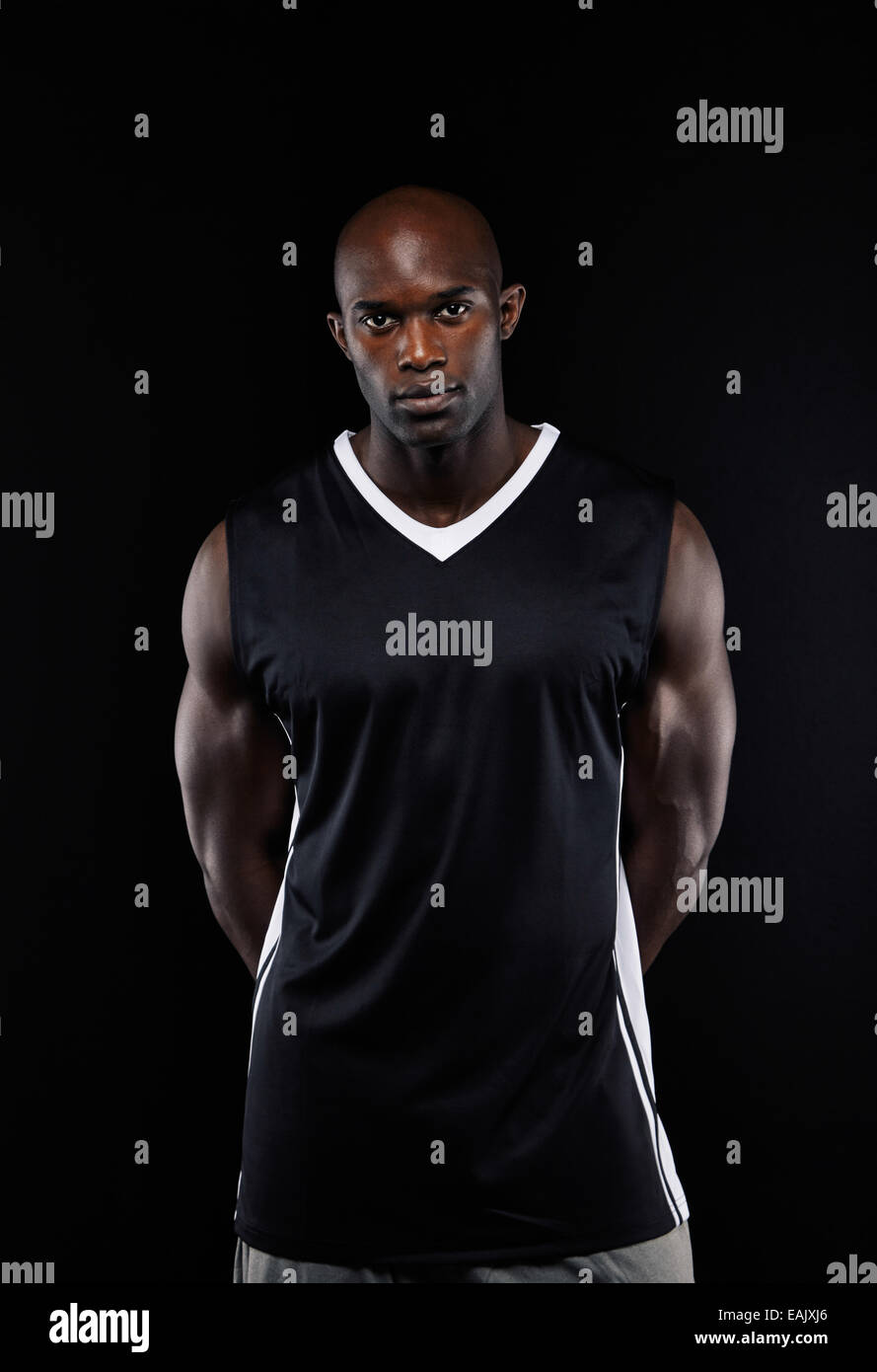 Porträt von überzeugt junge afrikanische Basketballspieler auf schwarzem Hintergrund. Passen Sie junge Sportler, Blick in die Kamera. Stockfoto