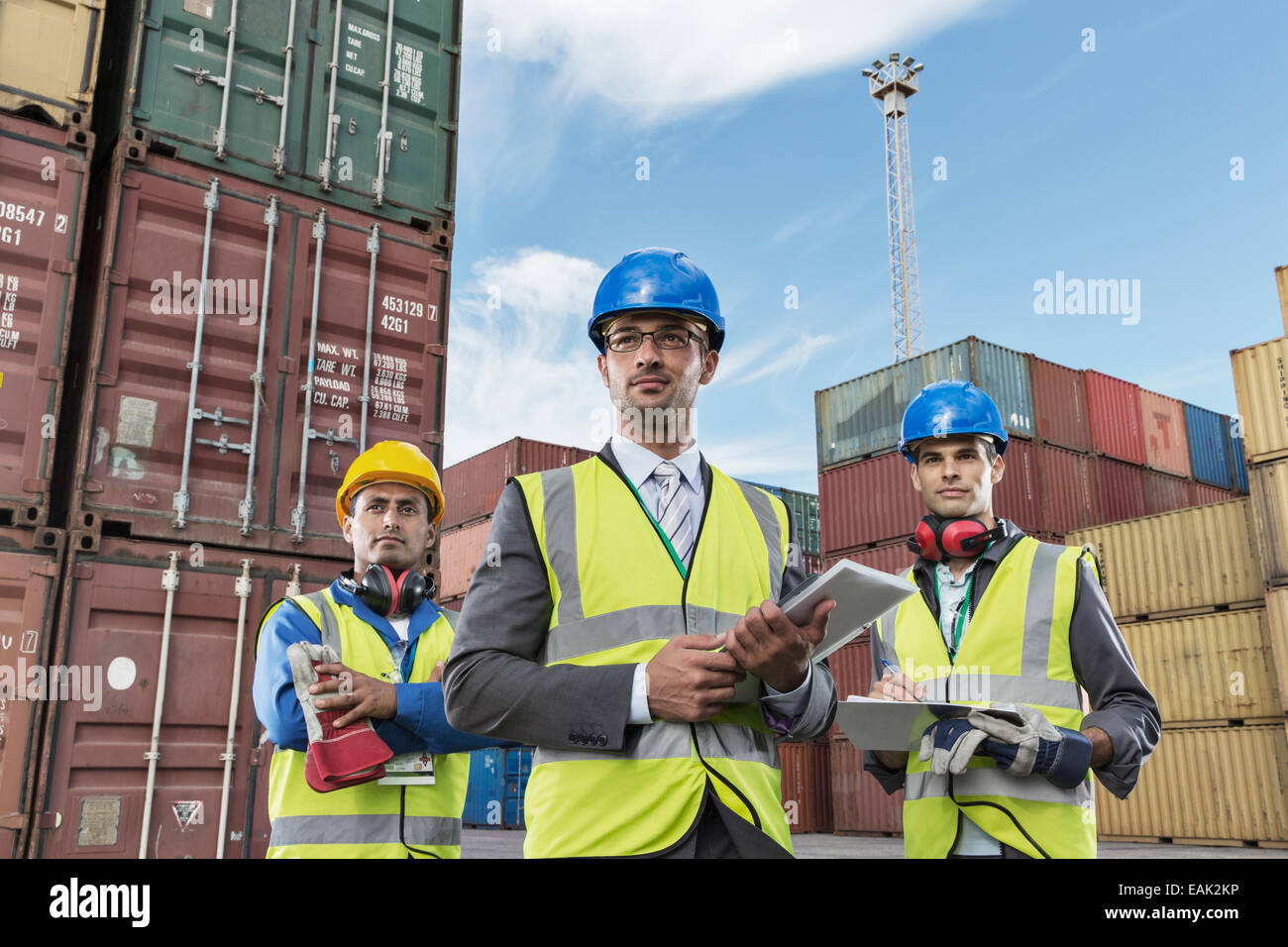 Unternehmer tragen Schutzkleidung in der Nähe von Containern Stockfoto