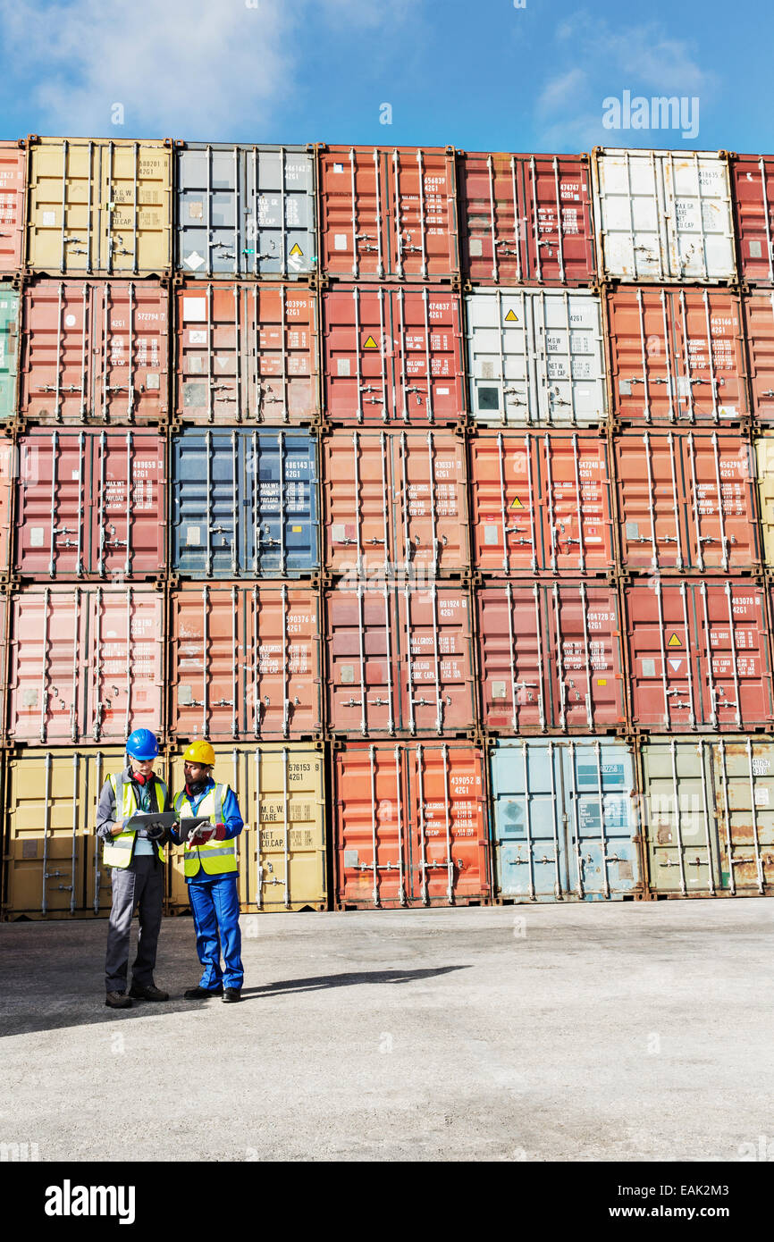 Unternehmer und Arbeiter in der Nähe von Containern im Gespräch Stockfoto
