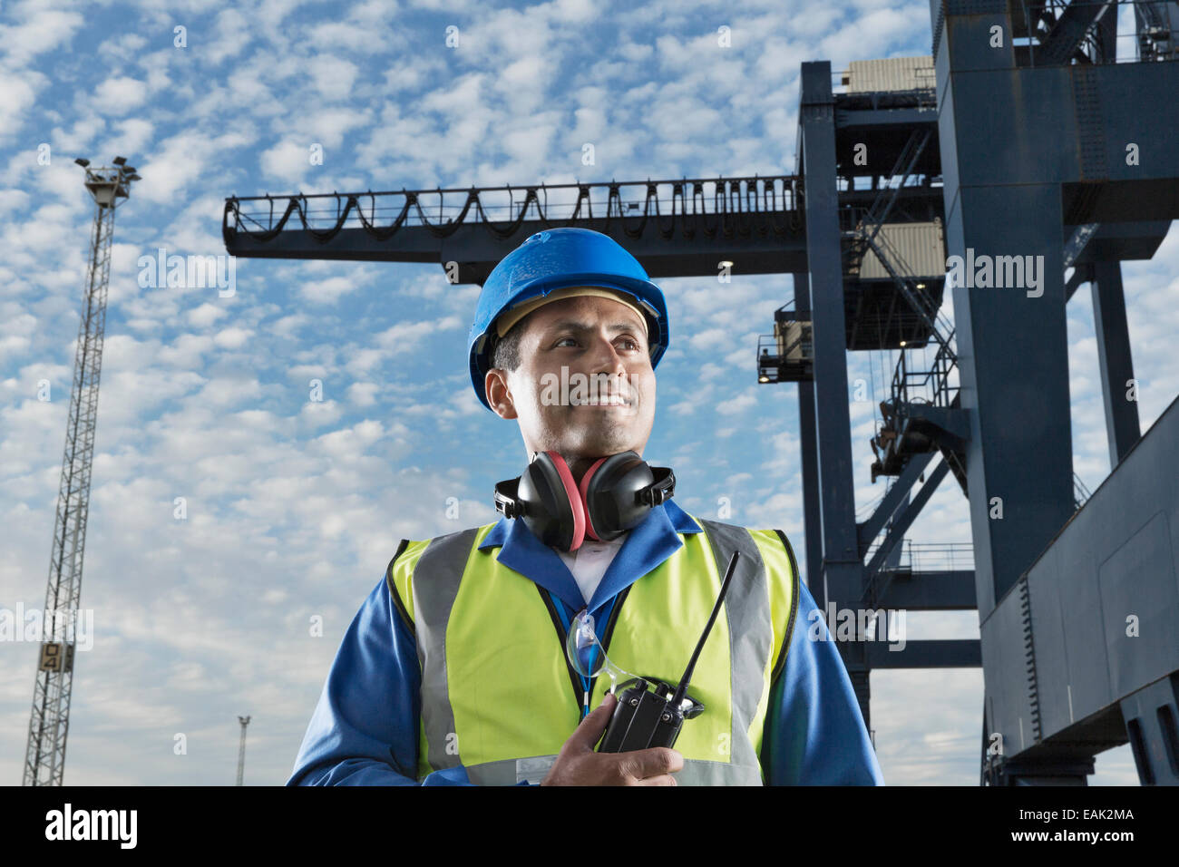 Arbeiter in der Nähe von Fracht Kran lächelnd Stockfoto