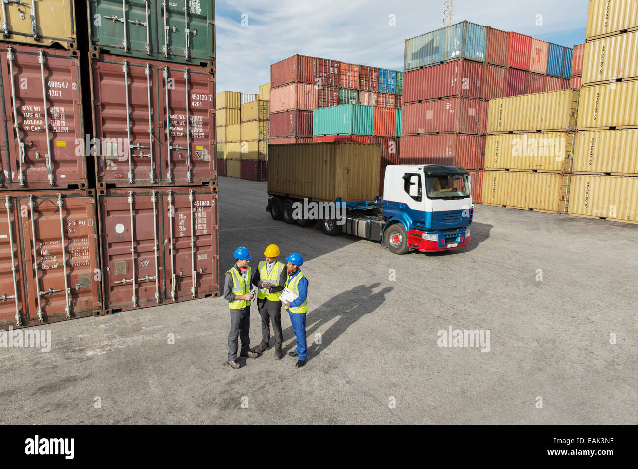 Unternehmer und Arbeiter in der Nähe von Containern im Gespräch Stockfoto