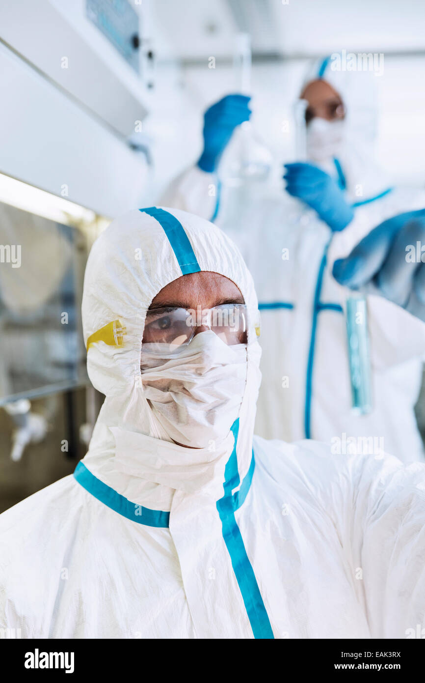 Wissenschaftler in sauberen Anzug Reagenzglas im Labor untersuchen Stockfoto