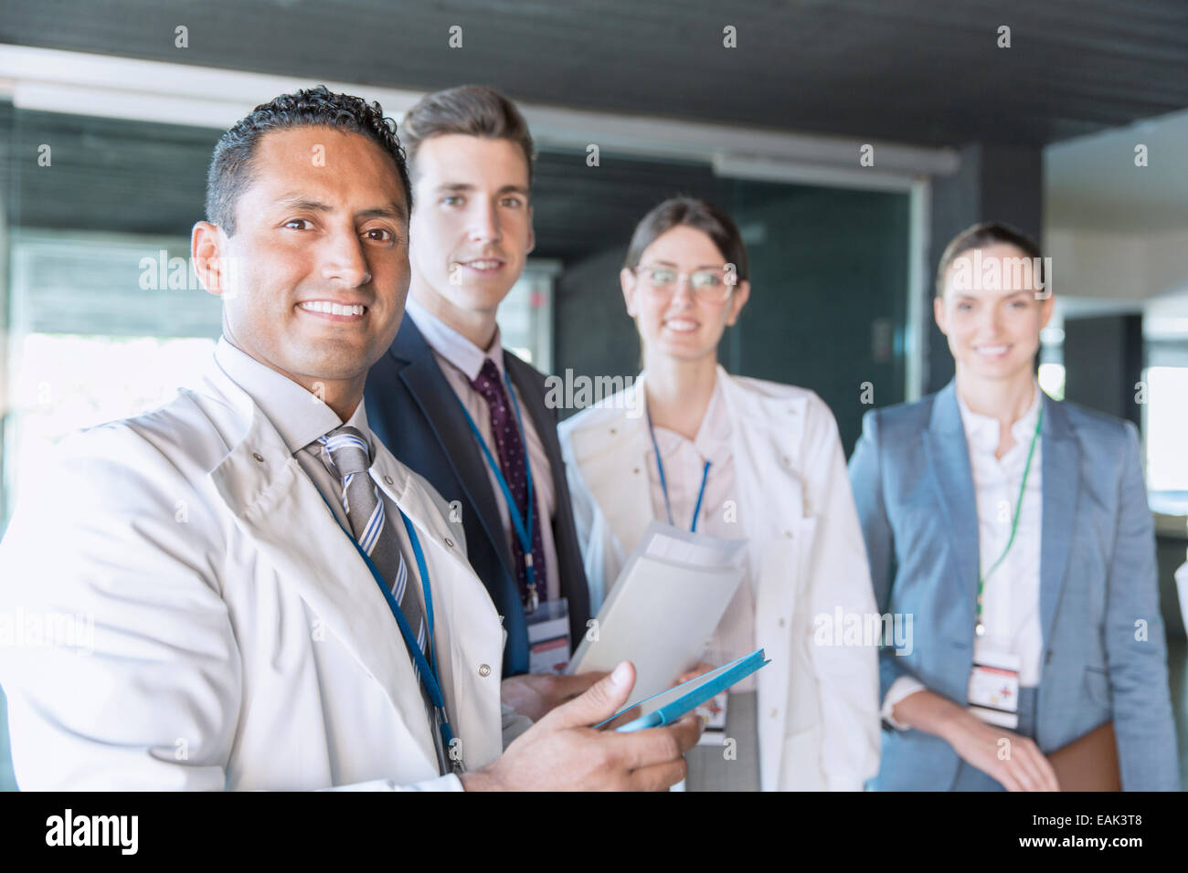 Wissenschaftler und Geschäftsleute, die lächelnd im Labor Stockfoto